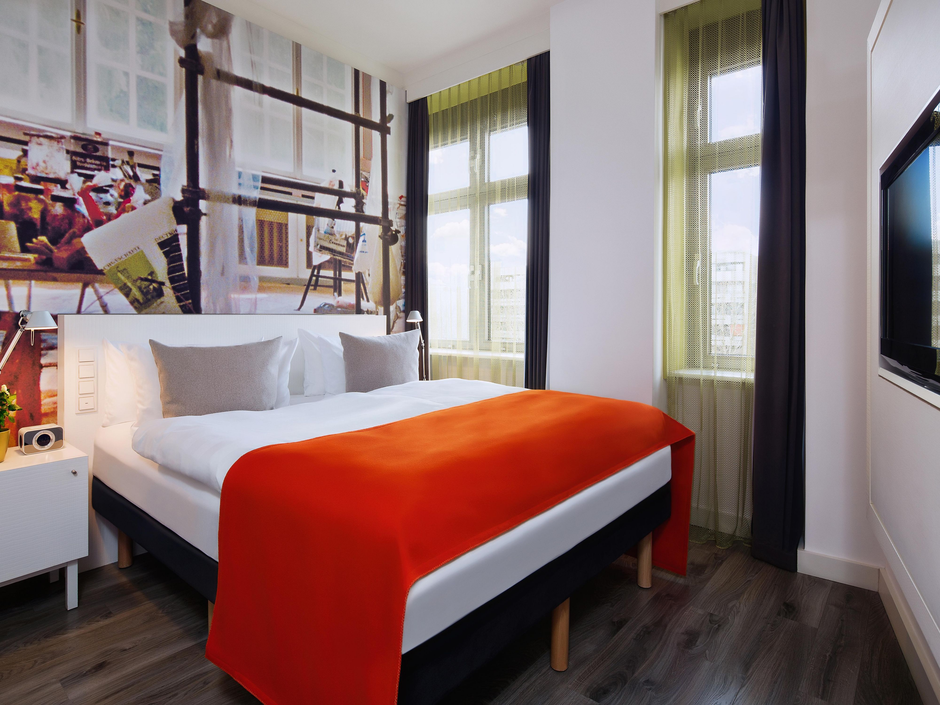 A guest room with a double bed and stylish wallpaper.