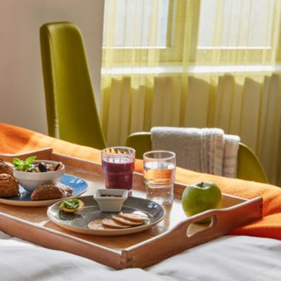 Breakfast in bed with a selection of rolls, deli meats and juice.