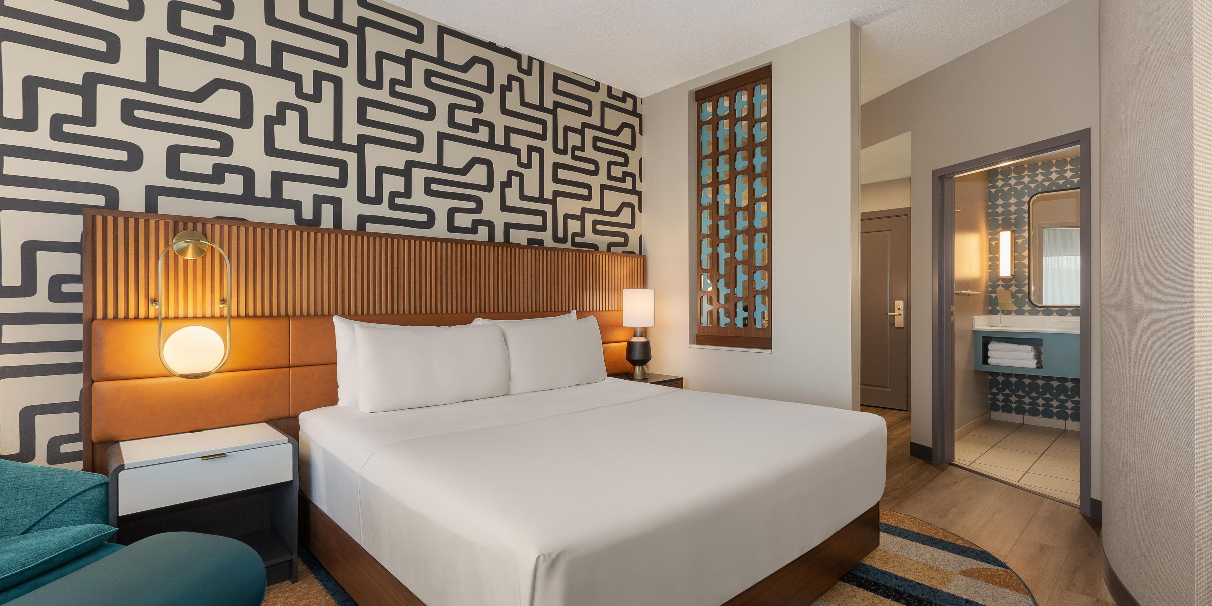 King bed surrounded by jewel tones, bold graphics create an oasis.