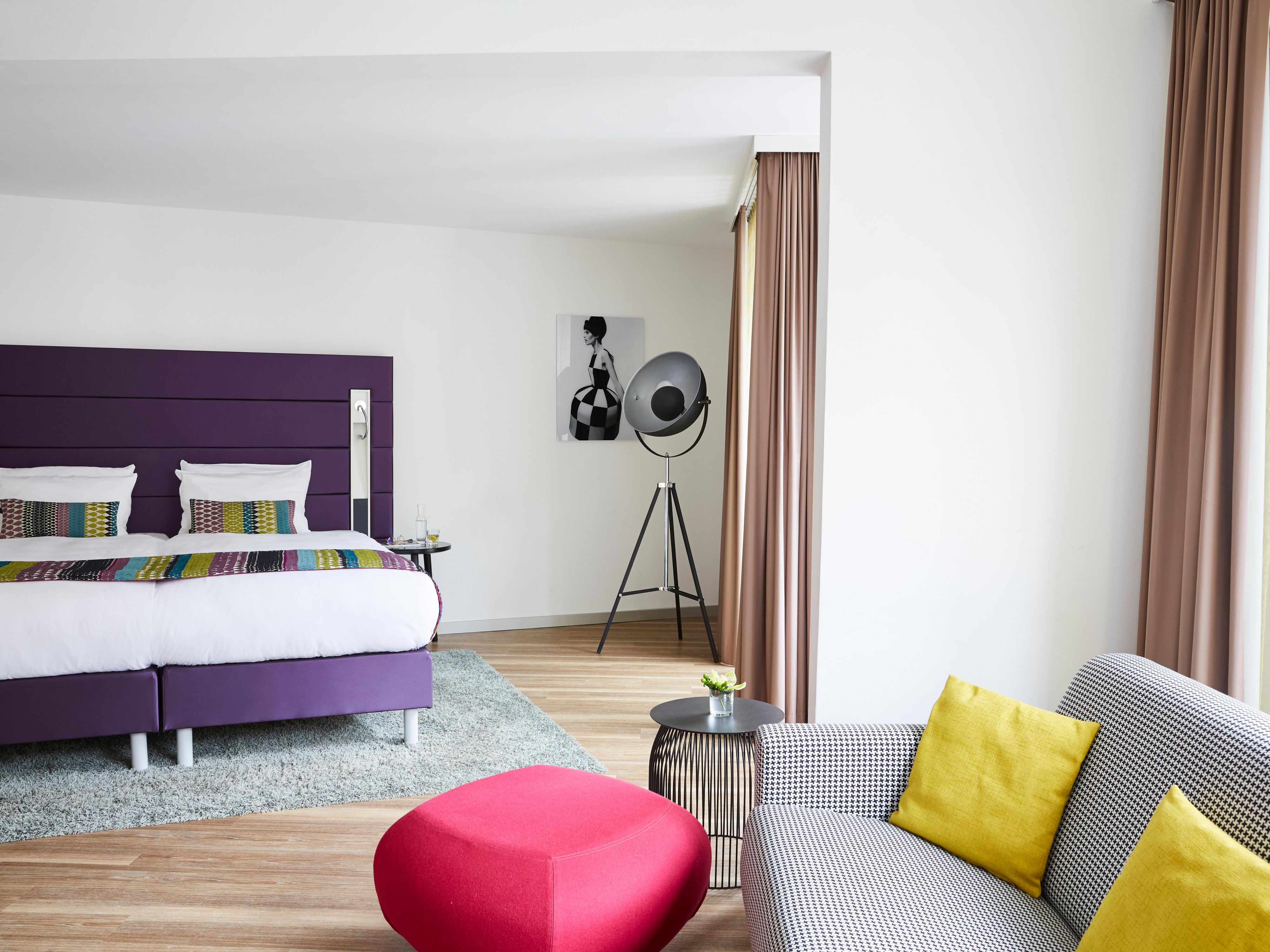 A spacious Junior Suite room in striking colours, with a sofa bed