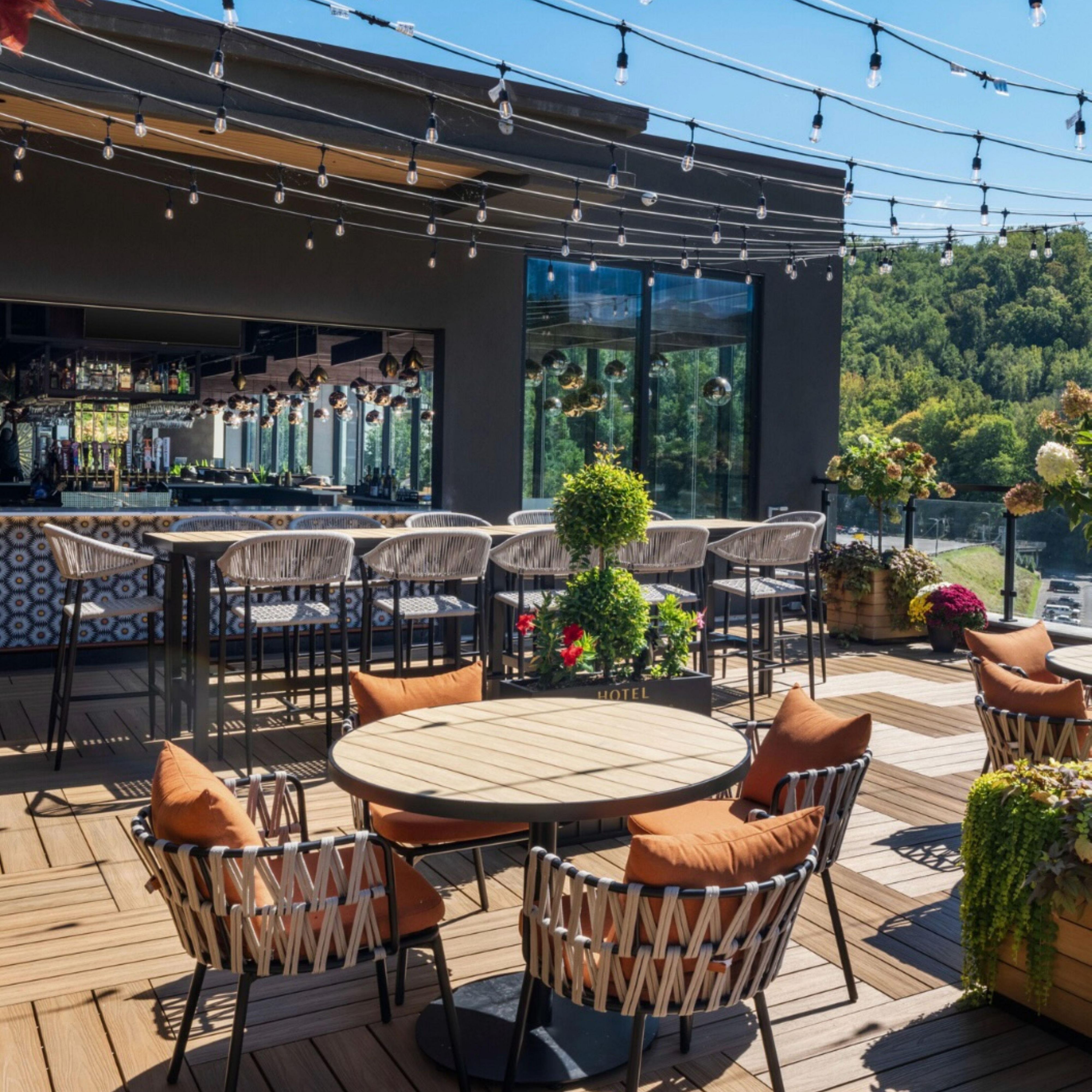 Outdoor hotel patio with tables, chairs, and greenery