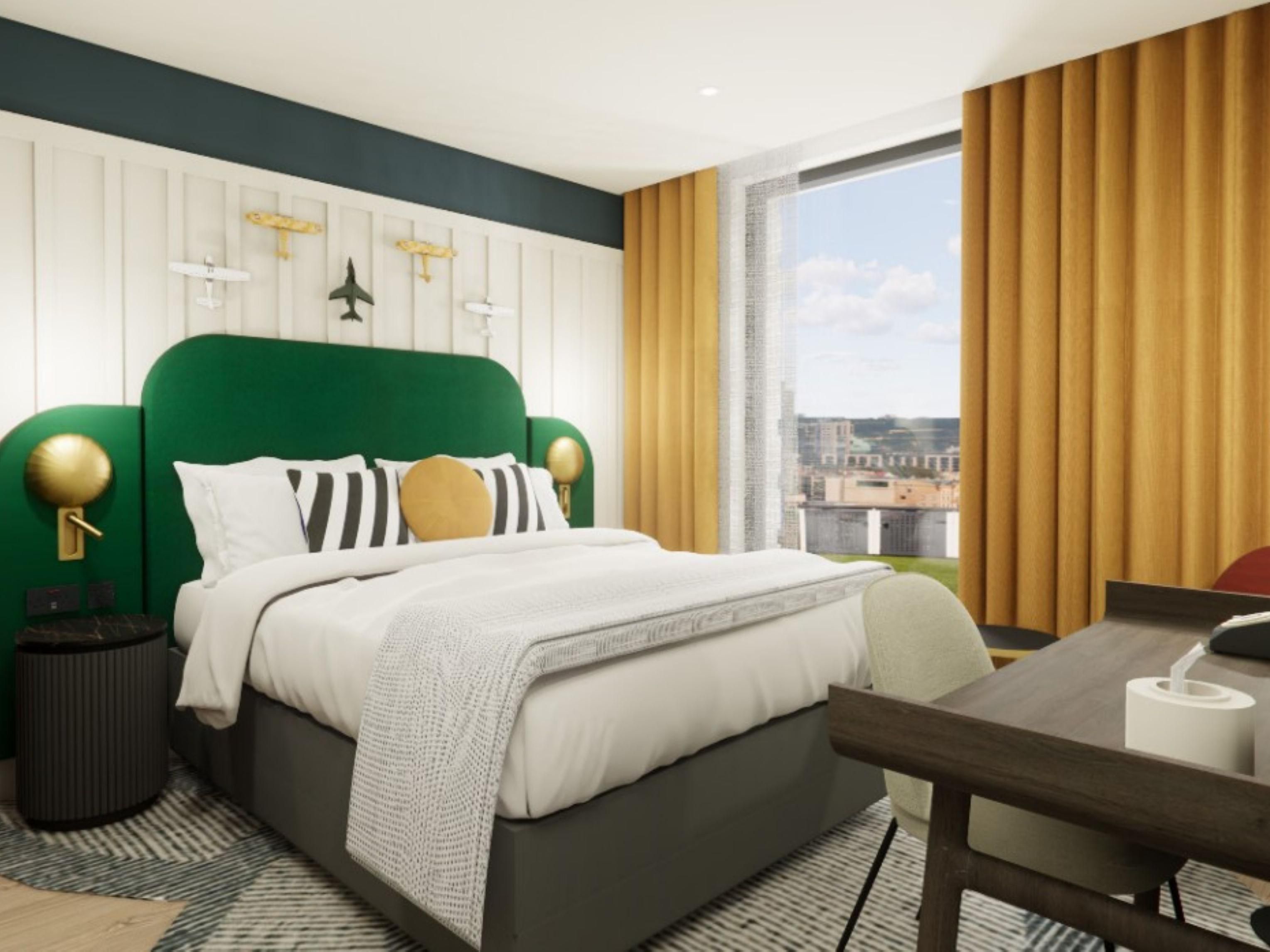 hotel guest bedroom with green bed, plane wall decorations and city views