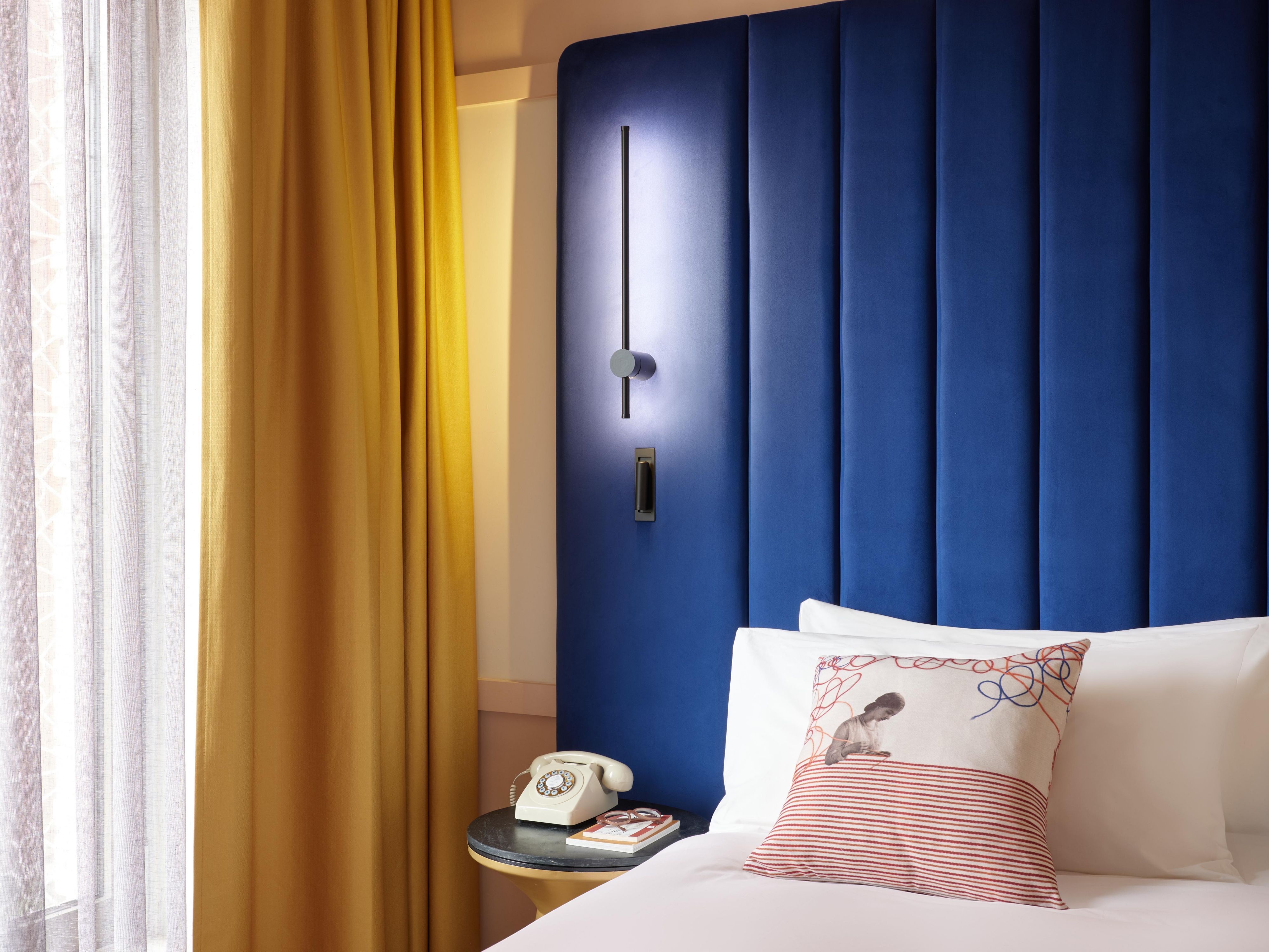 hotel guest room wirh blue bed backdrop and large window