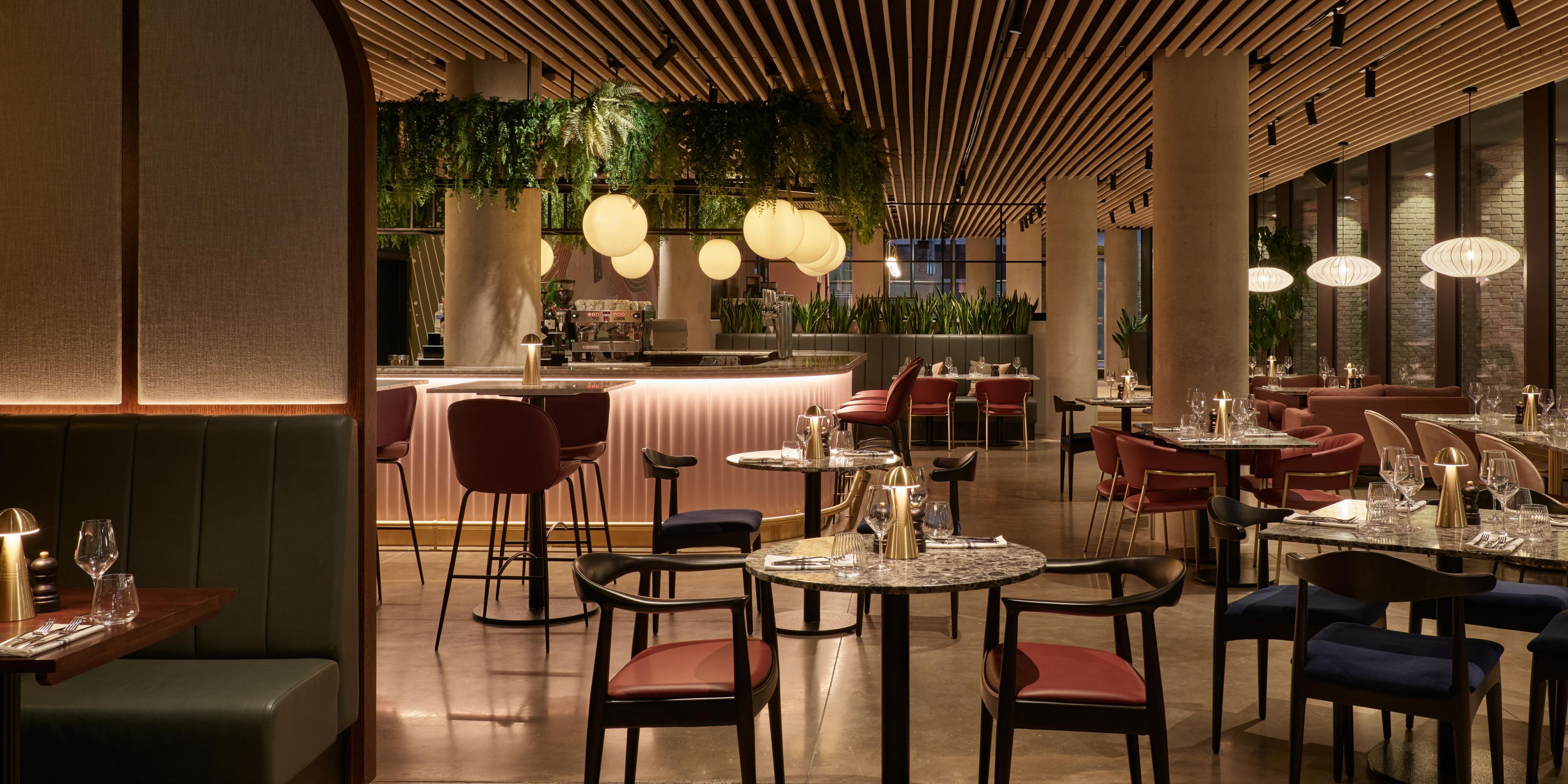 dim lit restaurant with plenty seating and a large pink bar