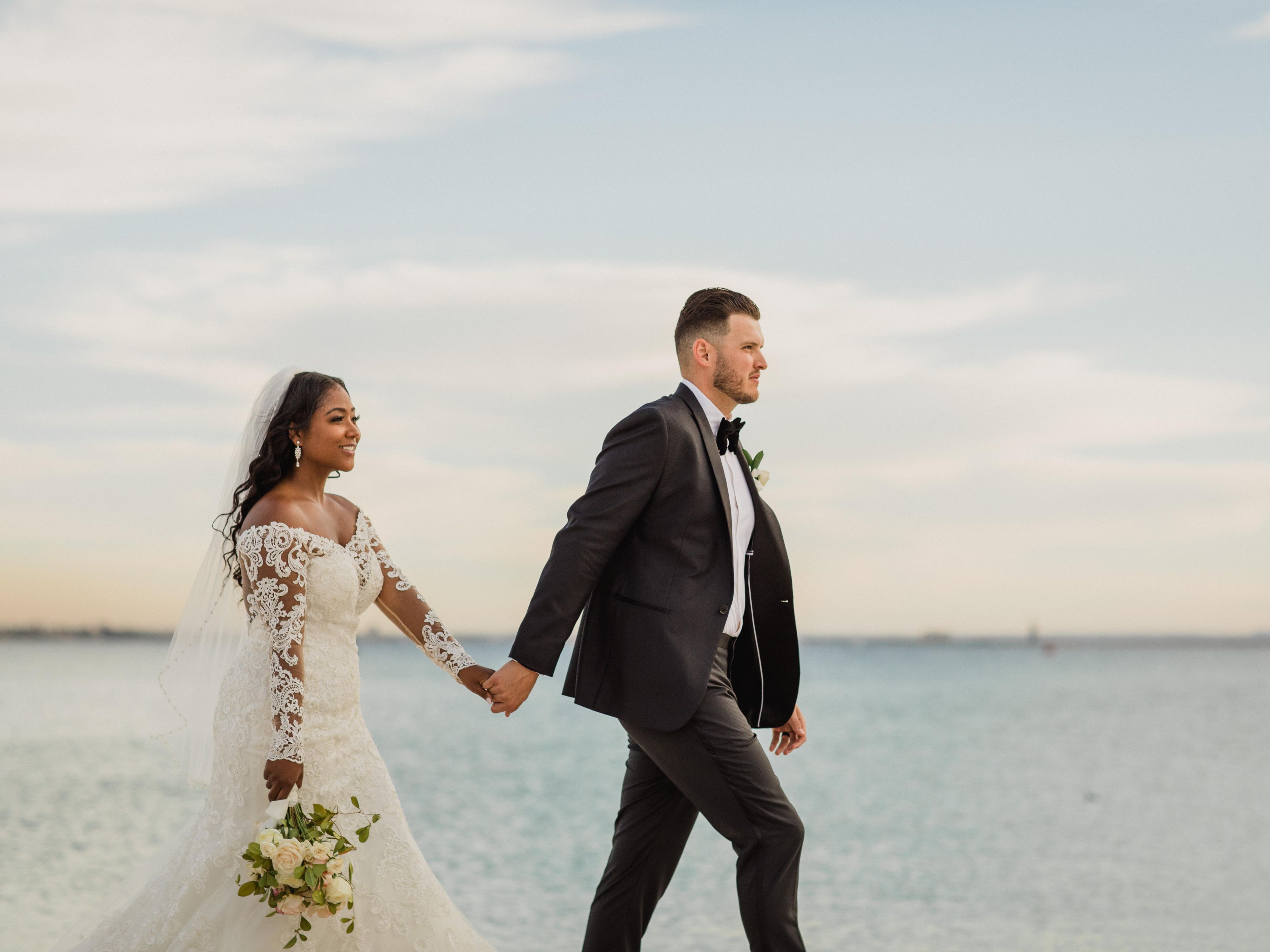 Pareja de novios caminando por la playa