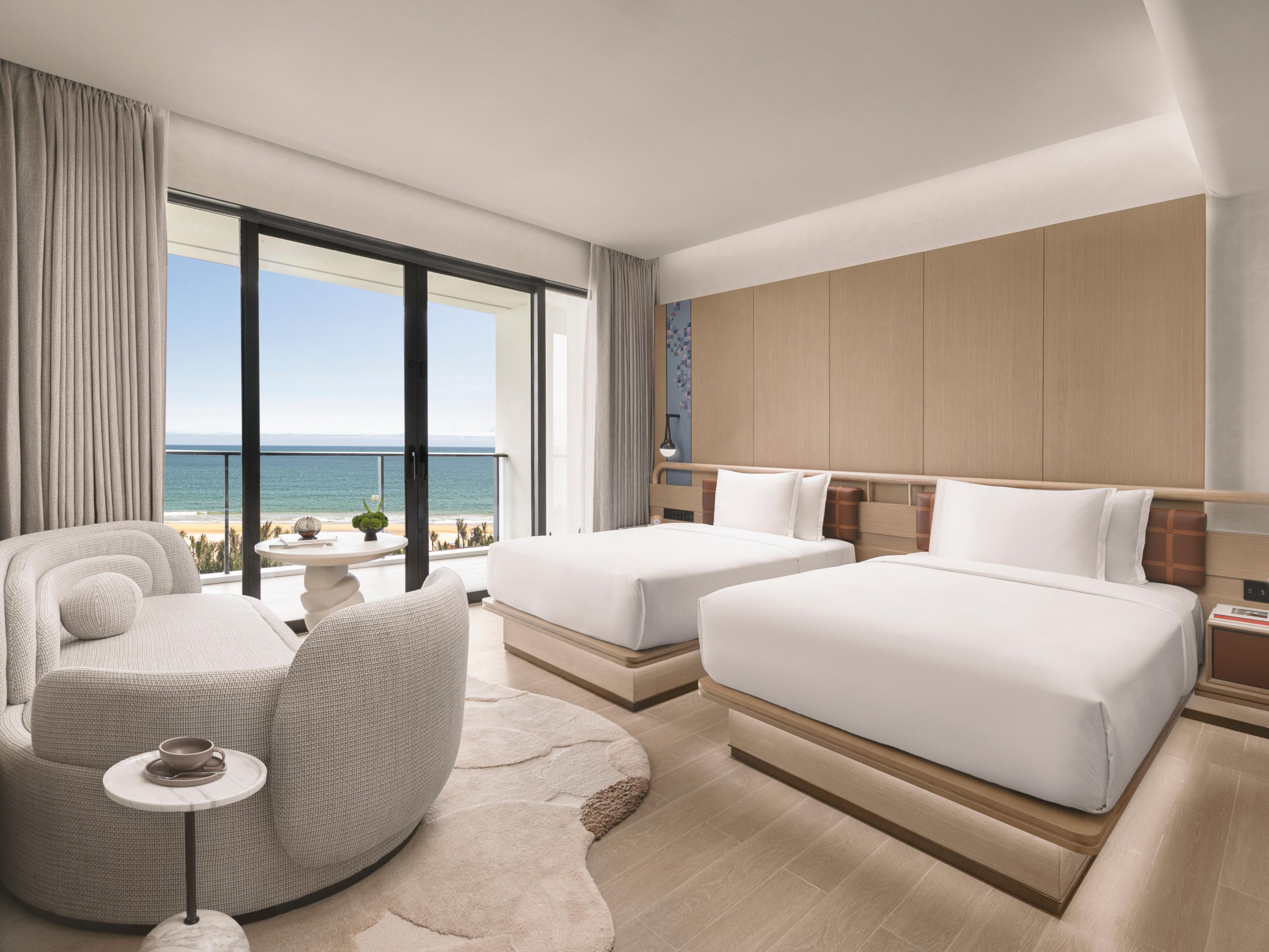 The guestroom hallway evokes a luxurious ship's cabin. All 174 rooms and suites blend modern design with Li ethnic weaving, offering ocean views or private pools. A beach-inspired palette, Marshall speakers, Dyson hair dryers, and other premium amenities create a refined tropical retreat.