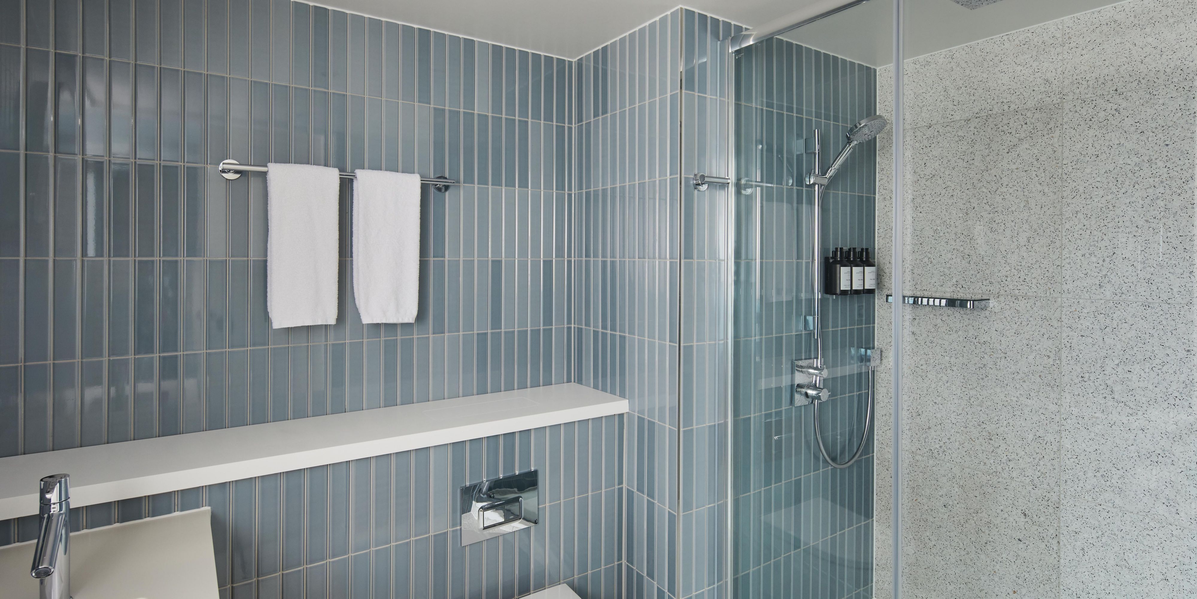 Enjoy the cool calm of our architect room's blue-tiled bathroom 