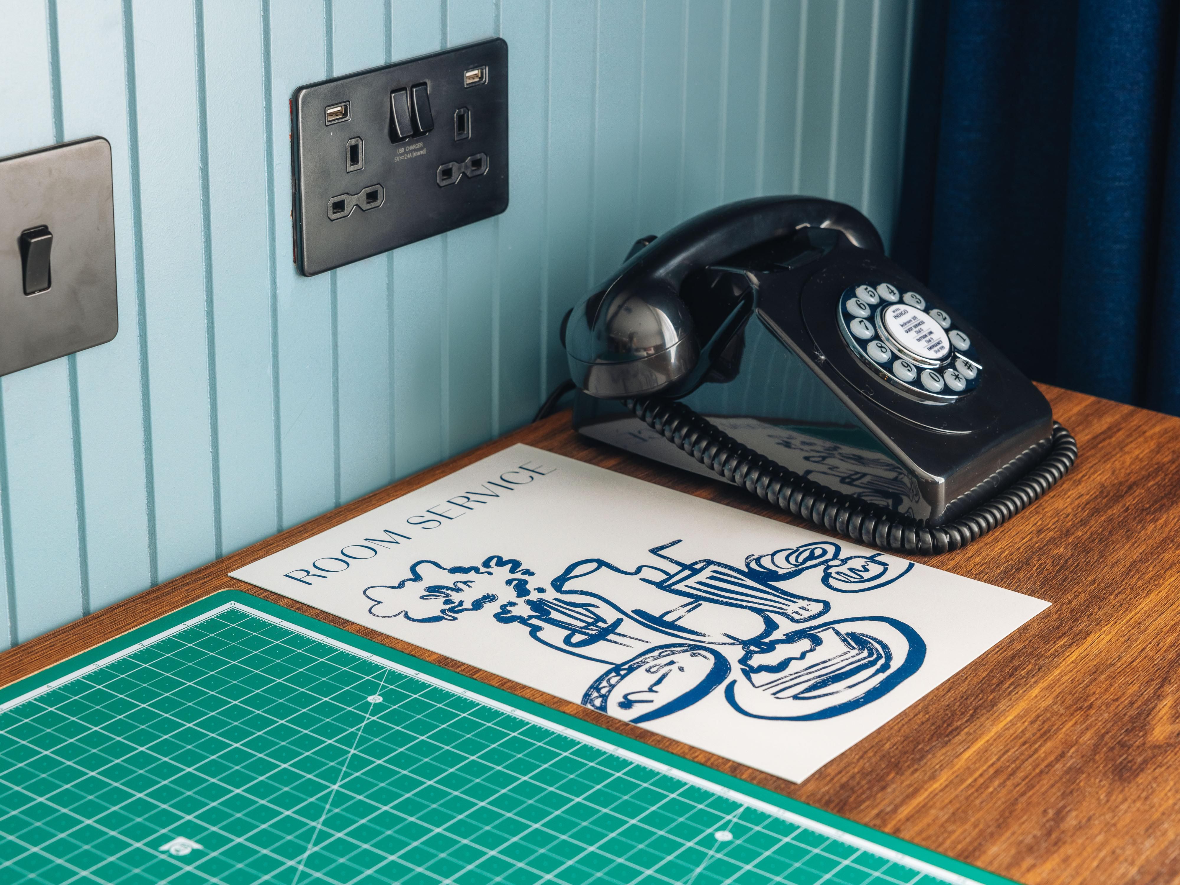 Desk with room service menu and phone.