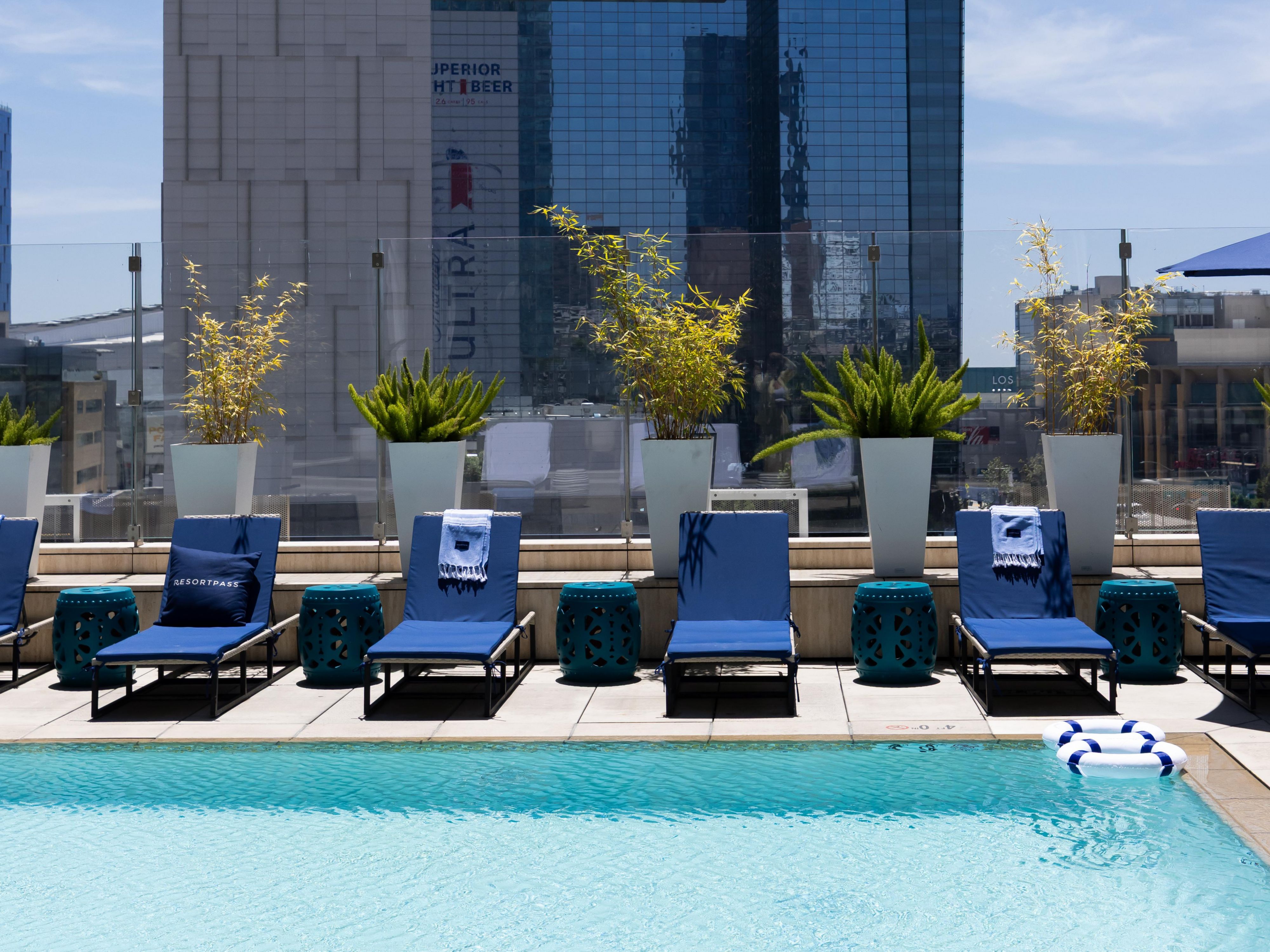 Pool chairs next to outdoor pool that overlooks downtown Los Angeles