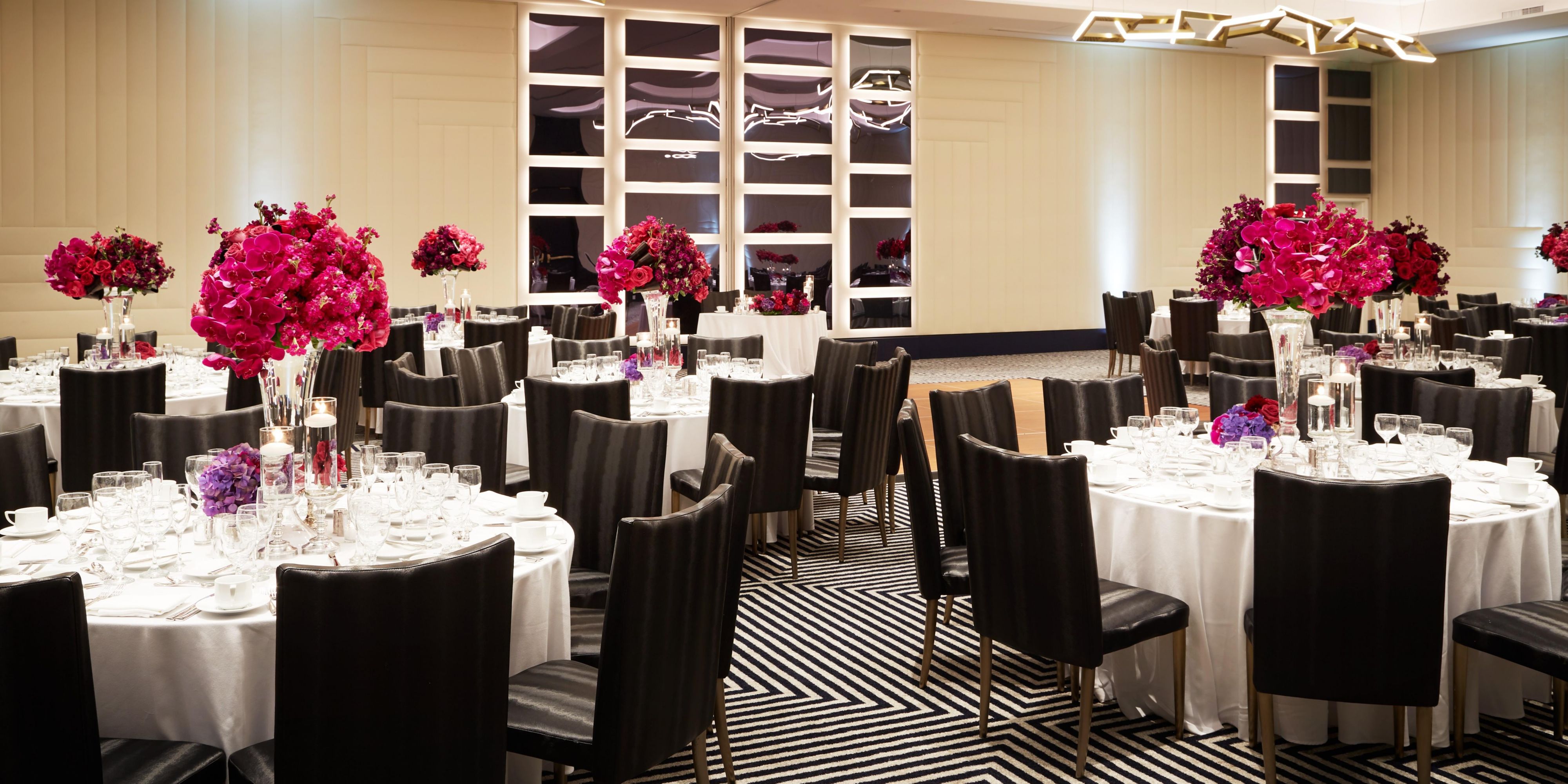 Ballroom setup with circular tables and flowers for wedding 