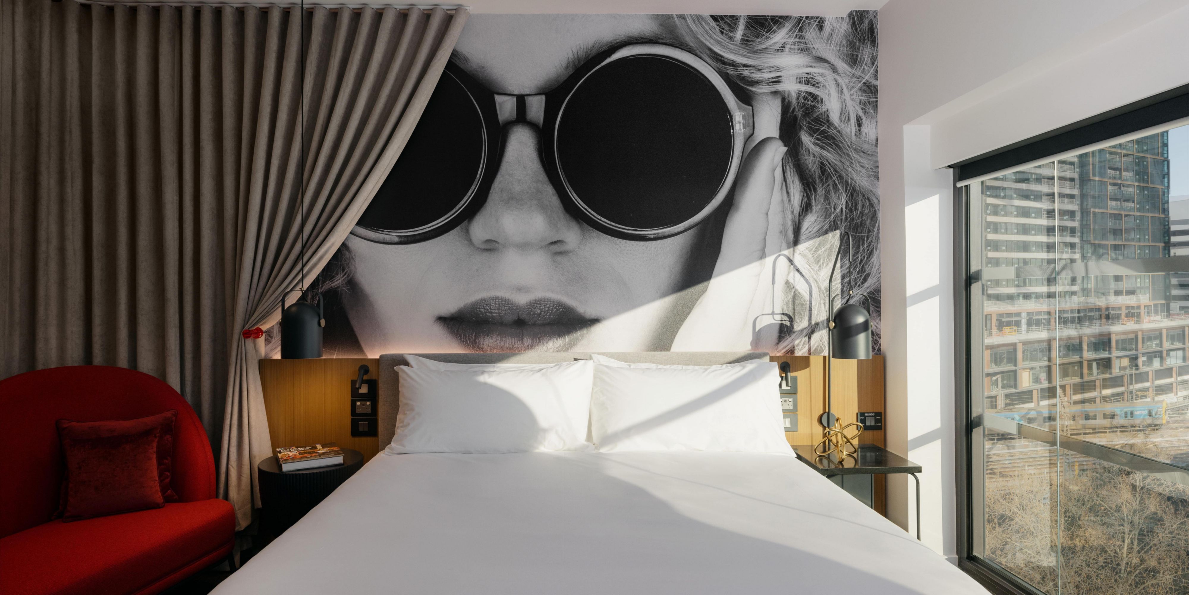 A monochrome face in sunglasses peeking behind your curtain