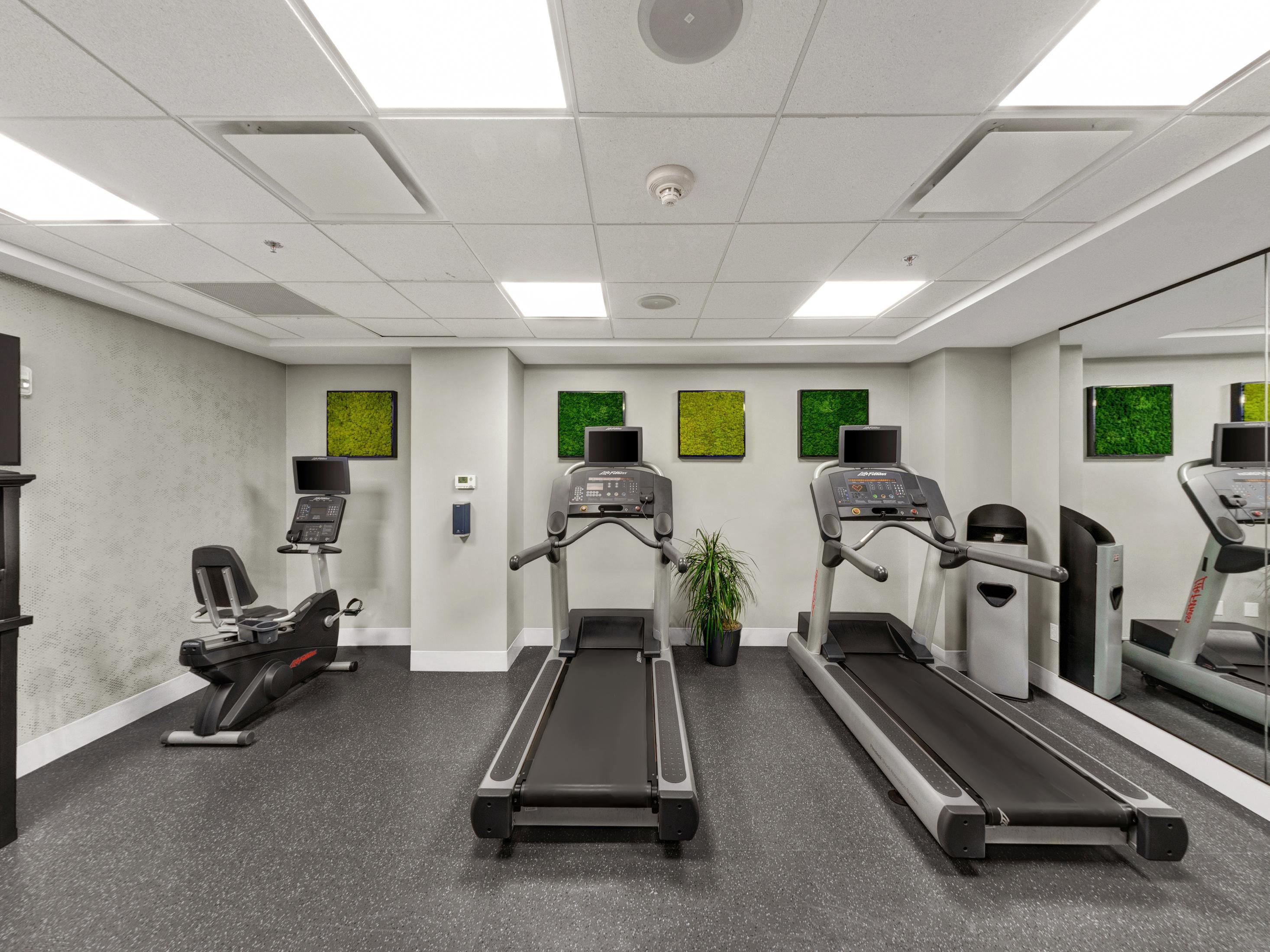 Fitness center with treadmills, elliptical machines, and yoga mats