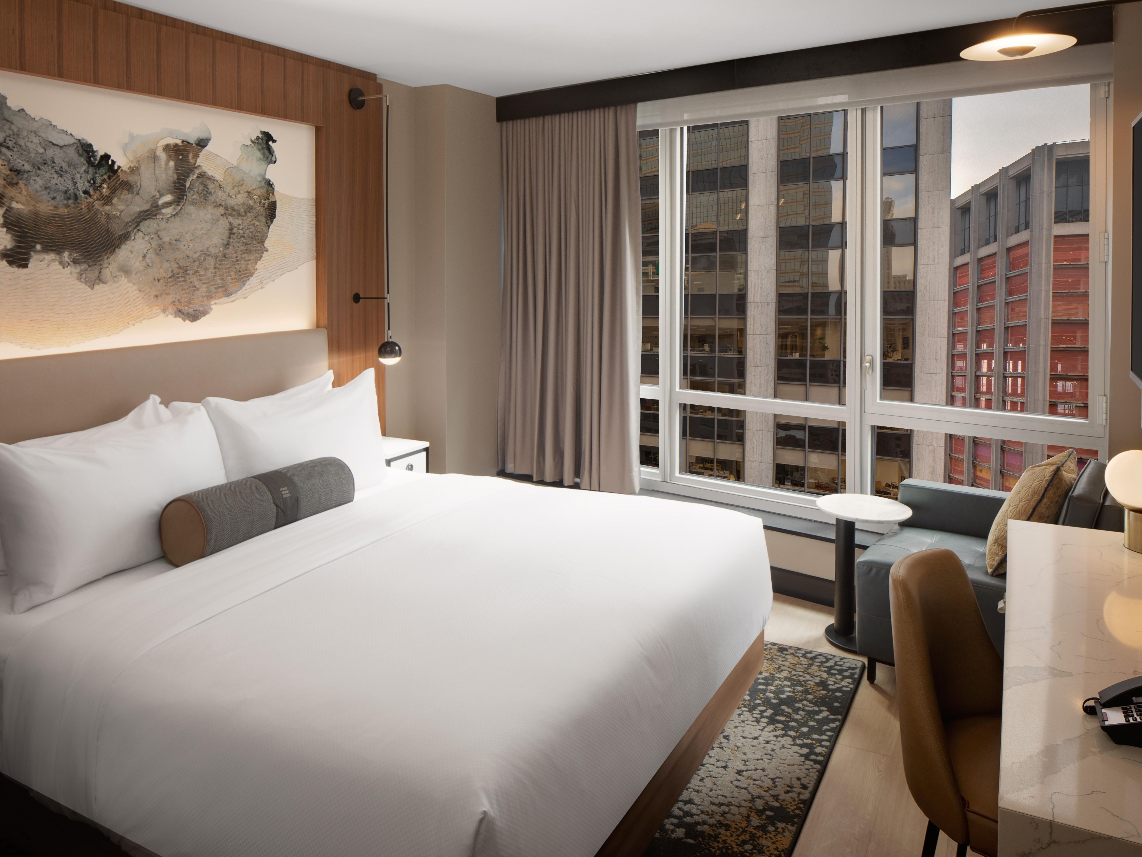 Bright and spacious hotel room with marble desk and leather chair