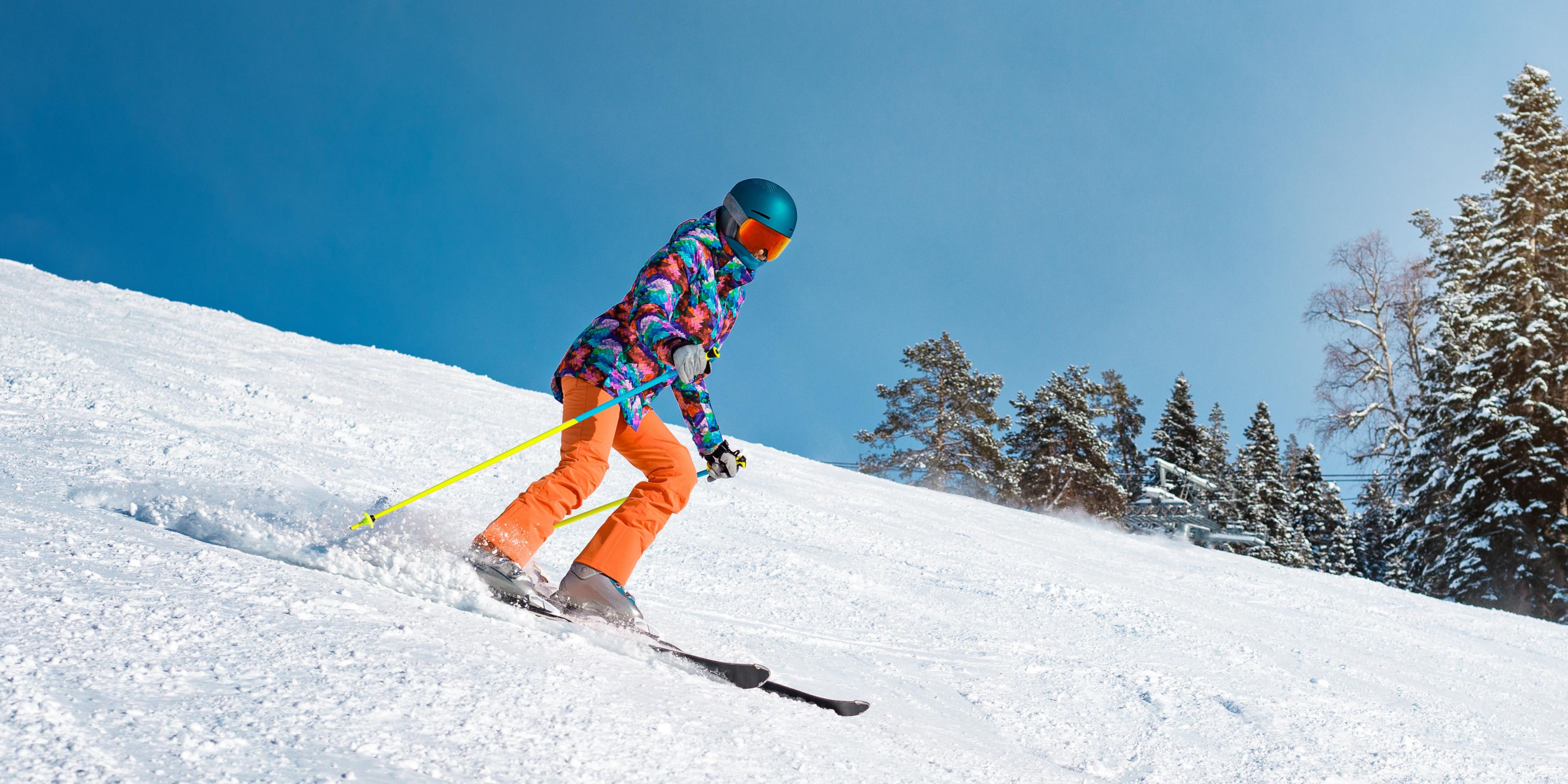 Skiier going down a snowy mountain.
