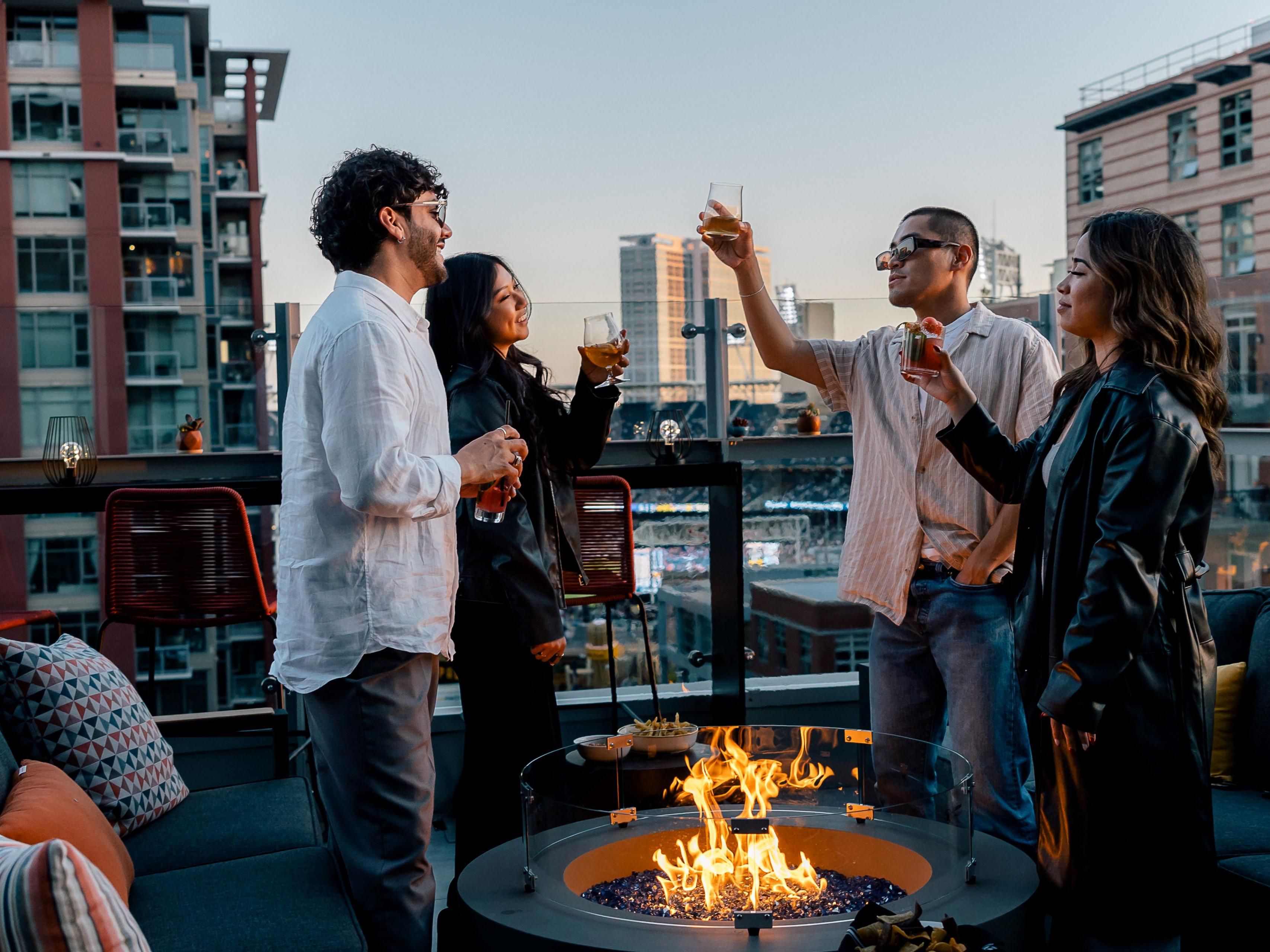Group of friends cheersing on rooftop by fire