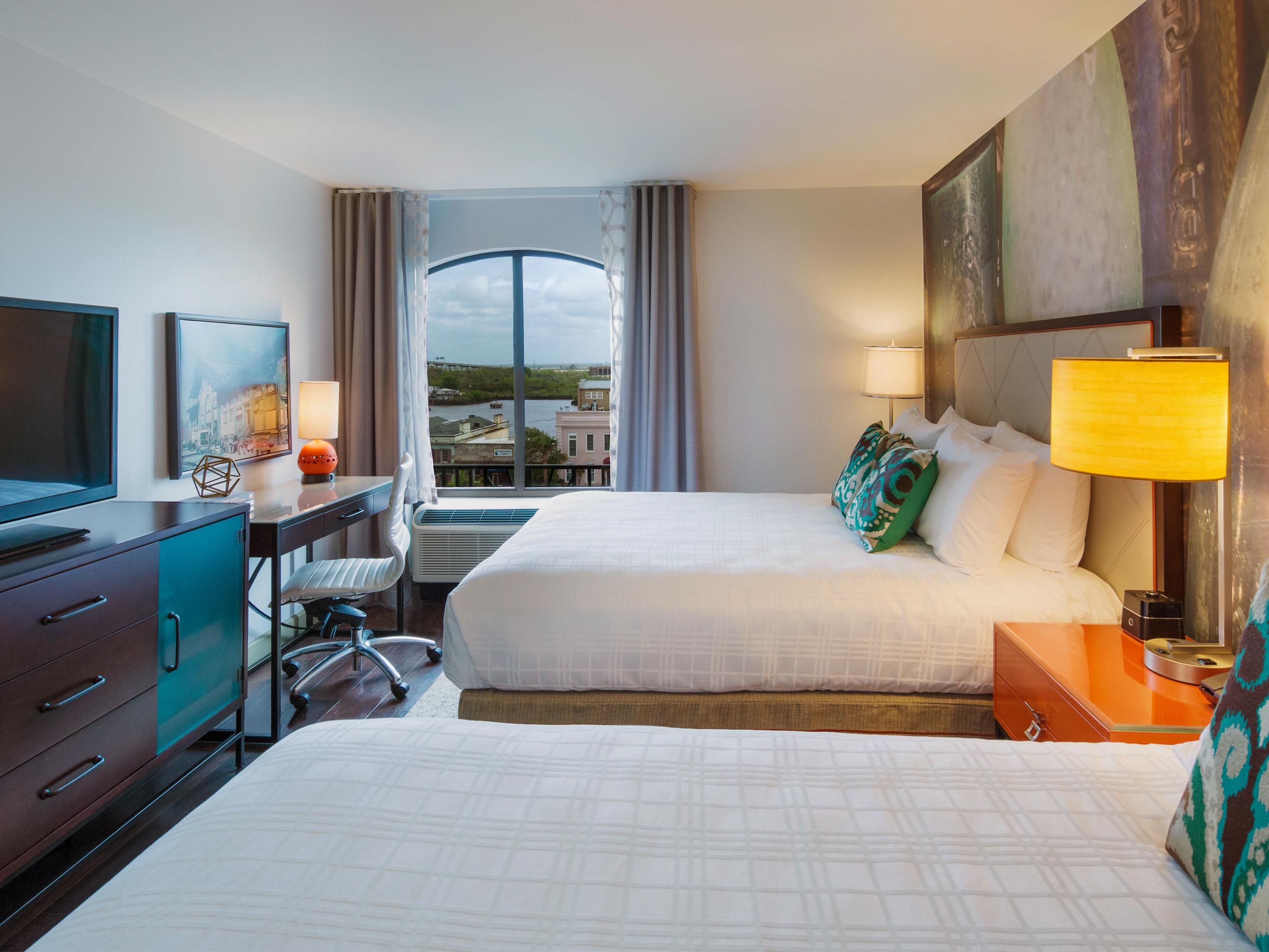 A hotel room with two beds and a view of the river in Savannah.