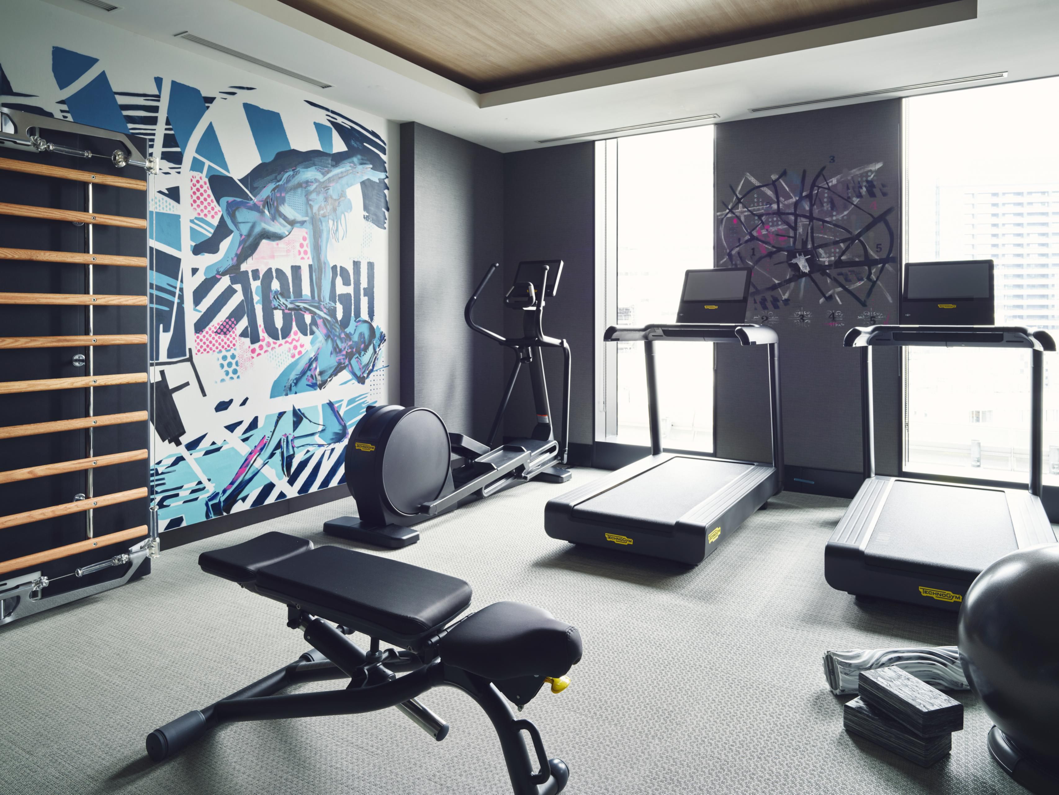 24/7 Gym with vibrant wall art for an immersive workout experience