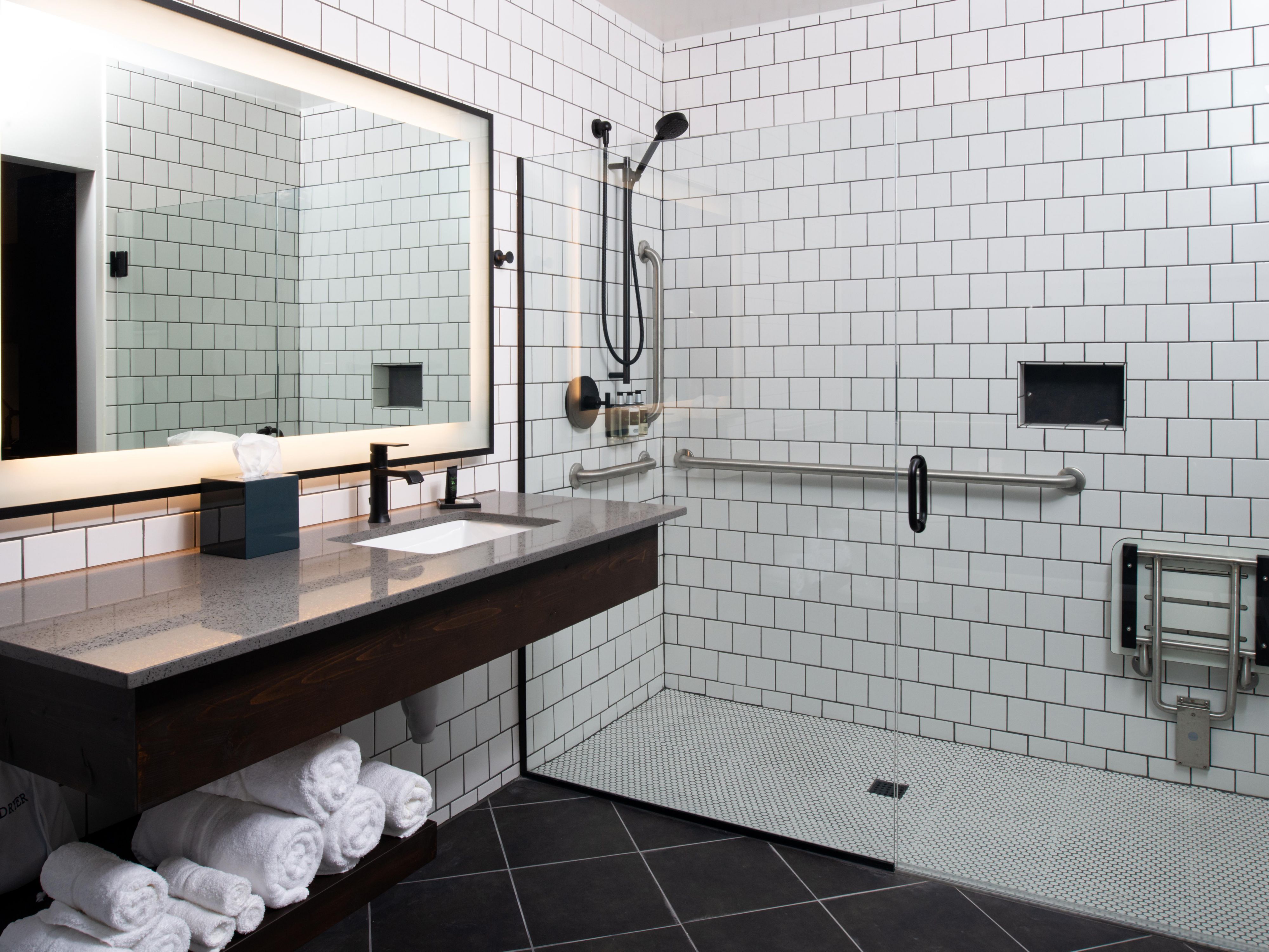 Spacious accessible guest bathroom with a roll-in shower.