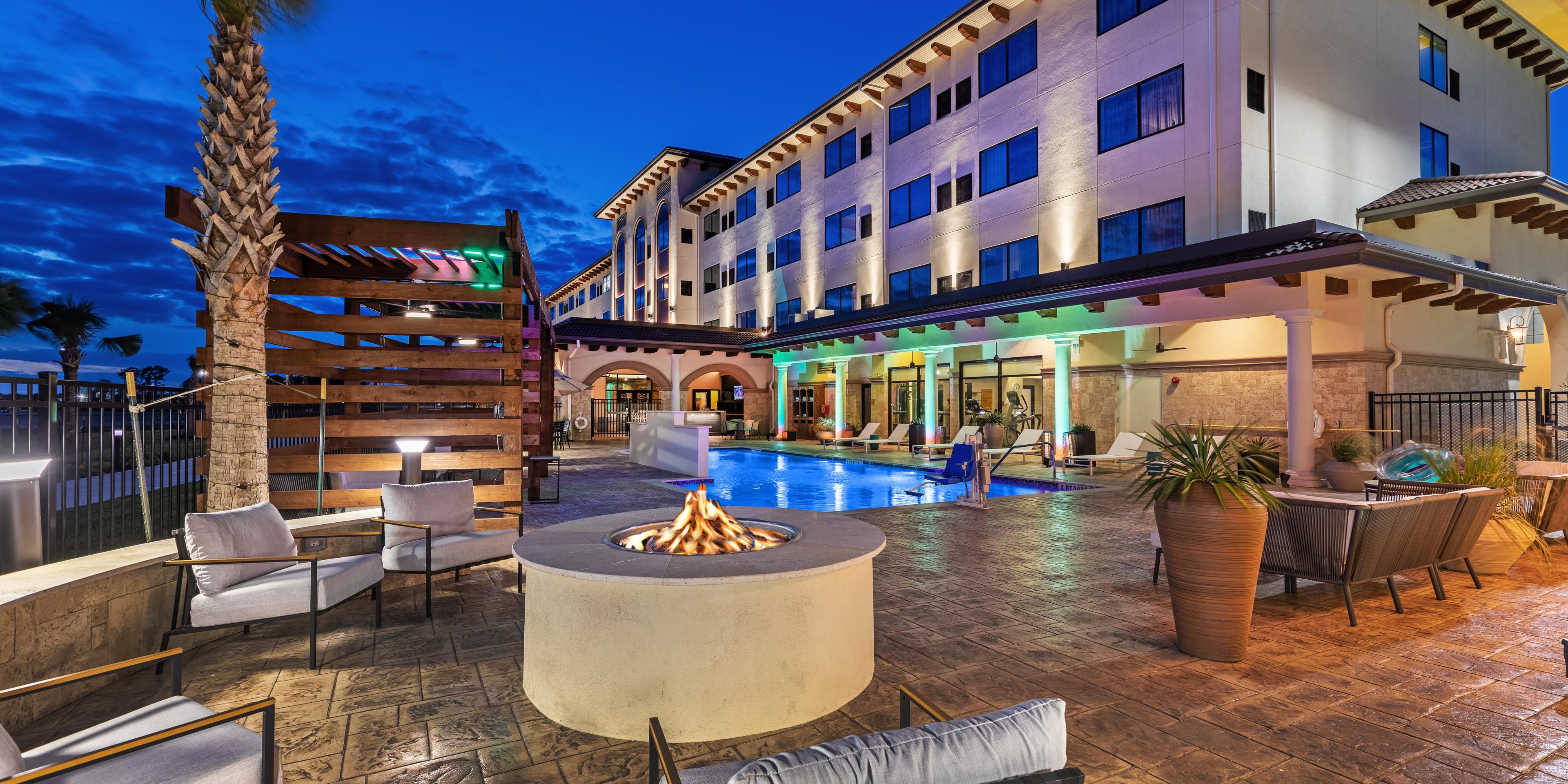 Outdoor pool at night w/ fire pit at Hotel Indigo Spring-Woodlands
