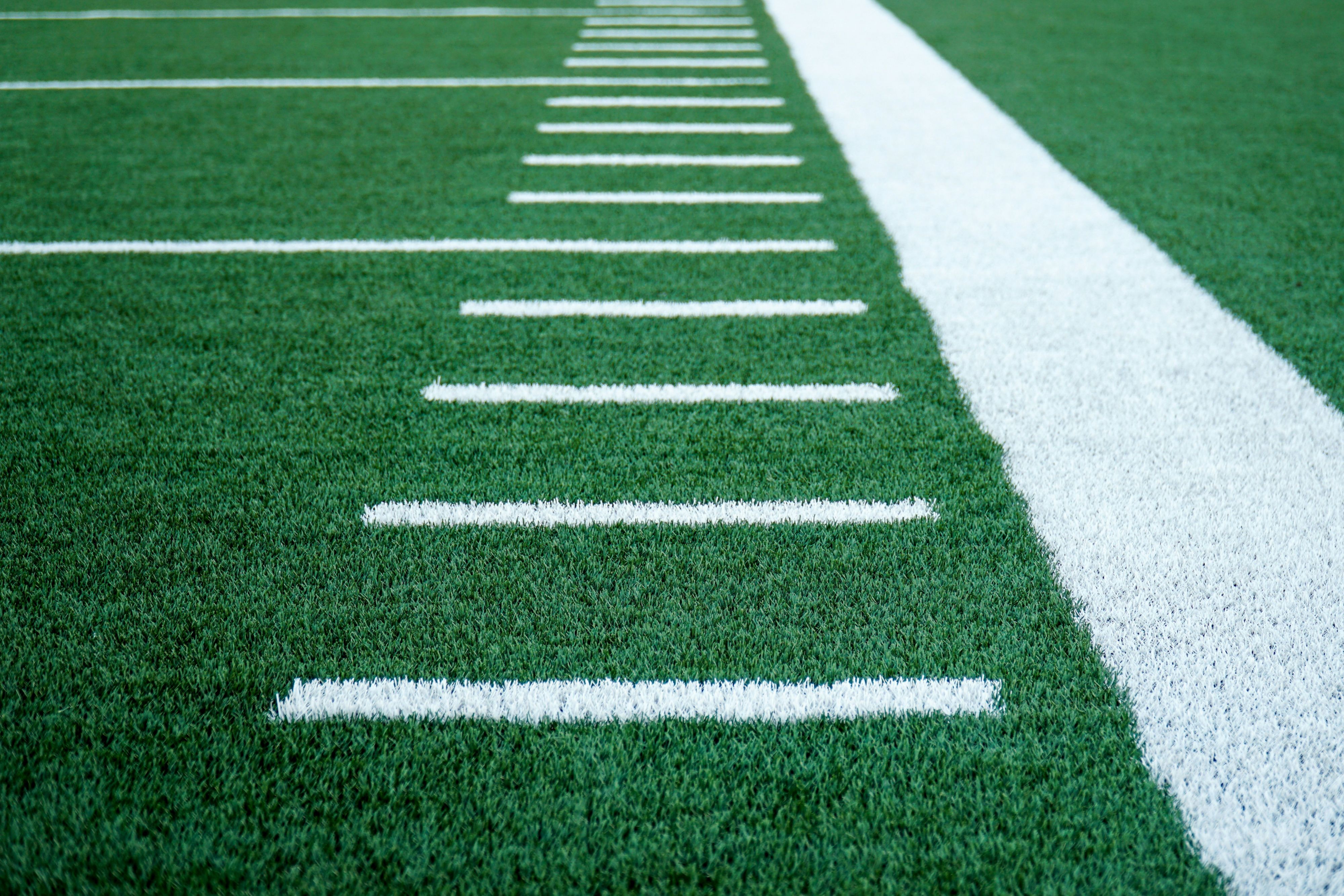 White yard lines painted on a football field sideline