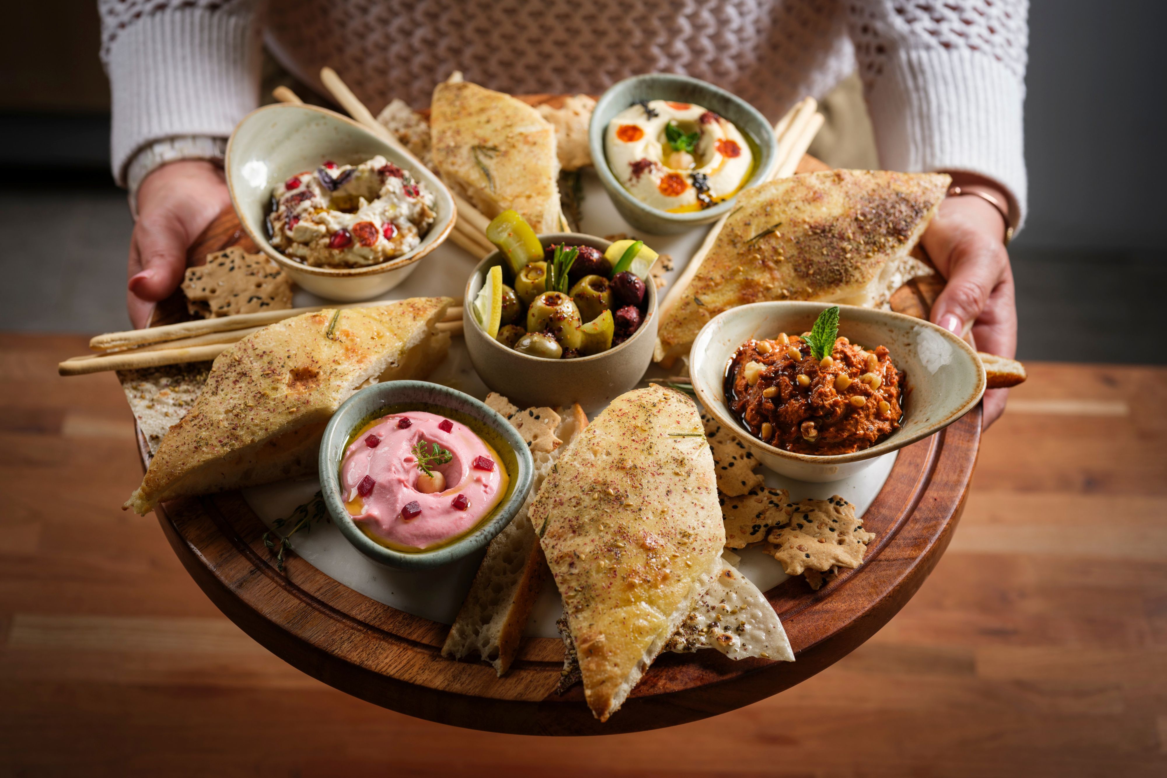 Mediterranean mezze board with dips, olives, pita, and crackers