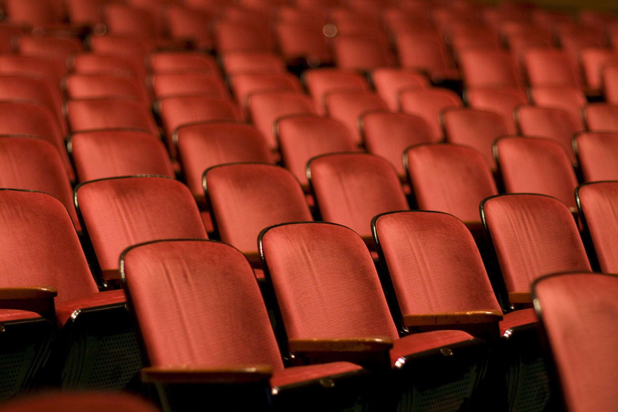 Rows of red theater seats inside a performance venue