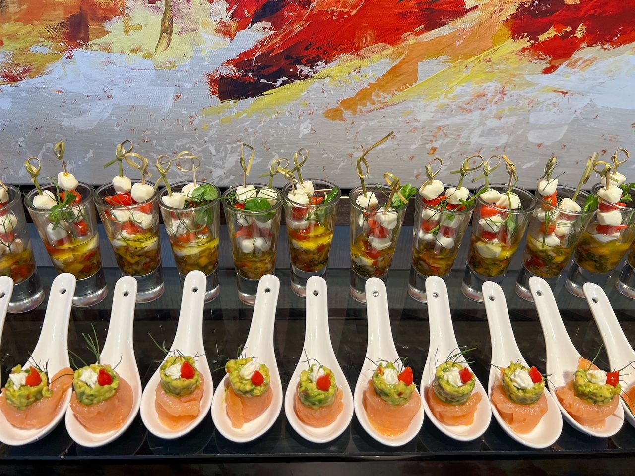 Assorted plated appetizers and small bites arranged in rows for an event display.