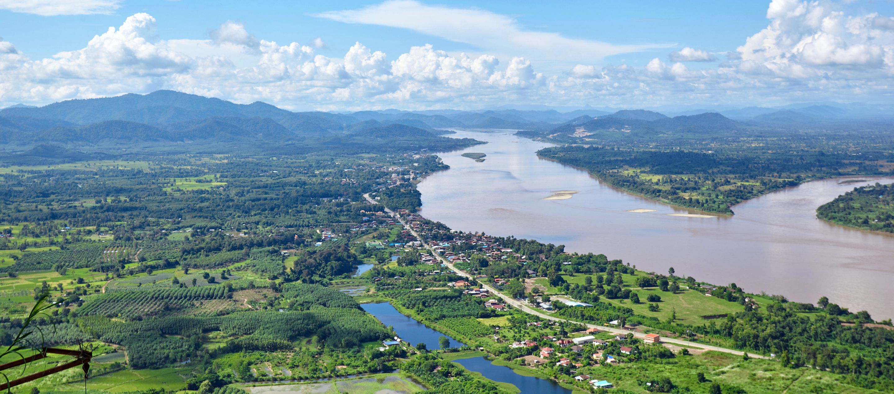 aerial view of chiang rai thailand with river running through lush farmland 