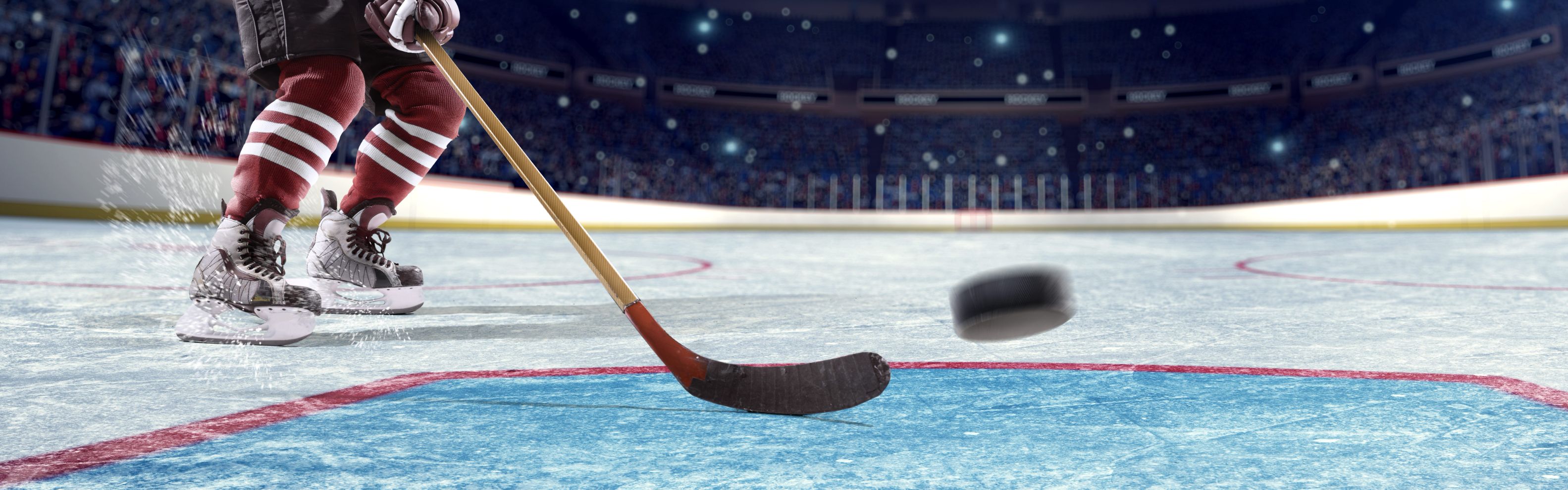 Hockey stick and puck on ice rink 