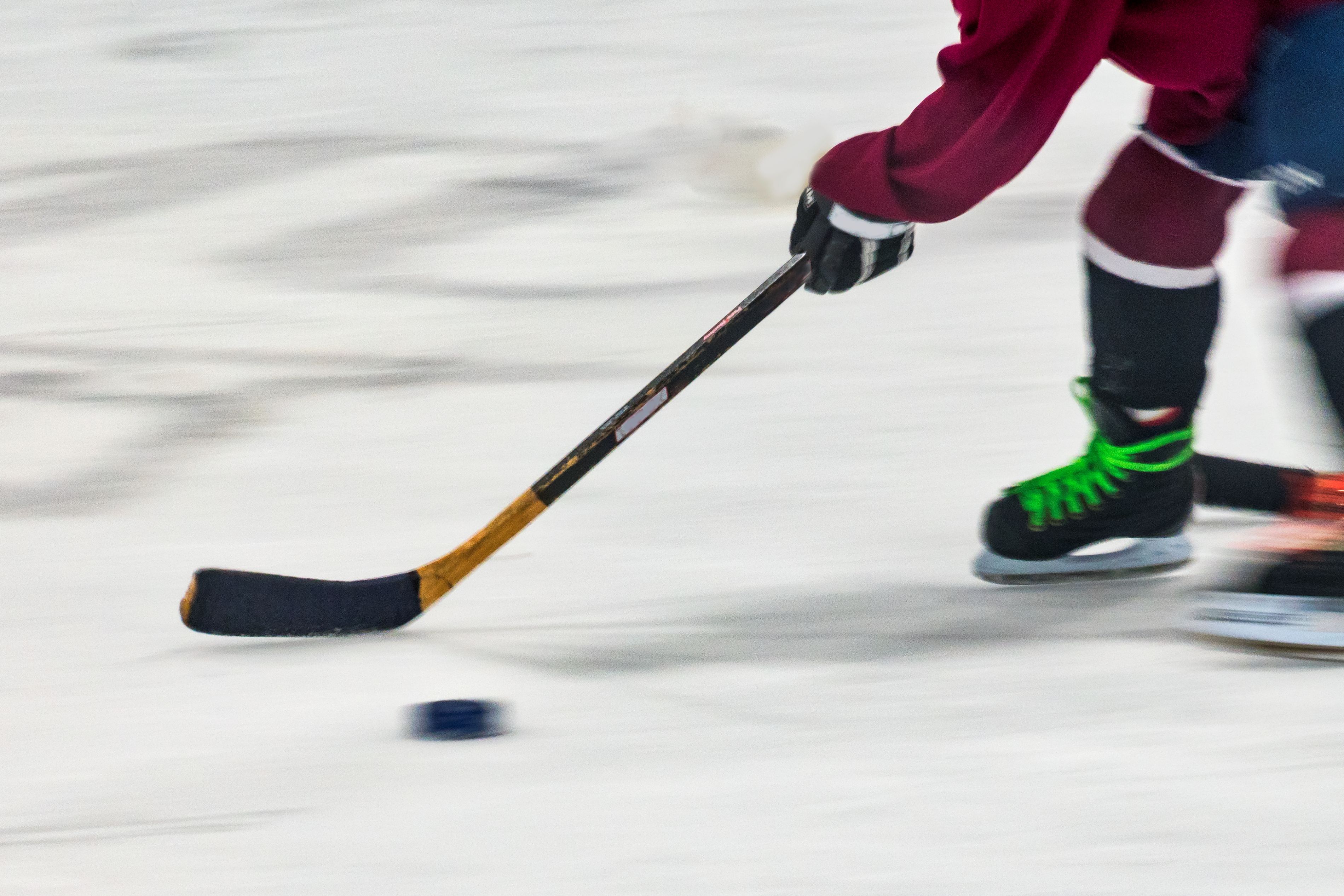Hockey puck and stick on ice rink.