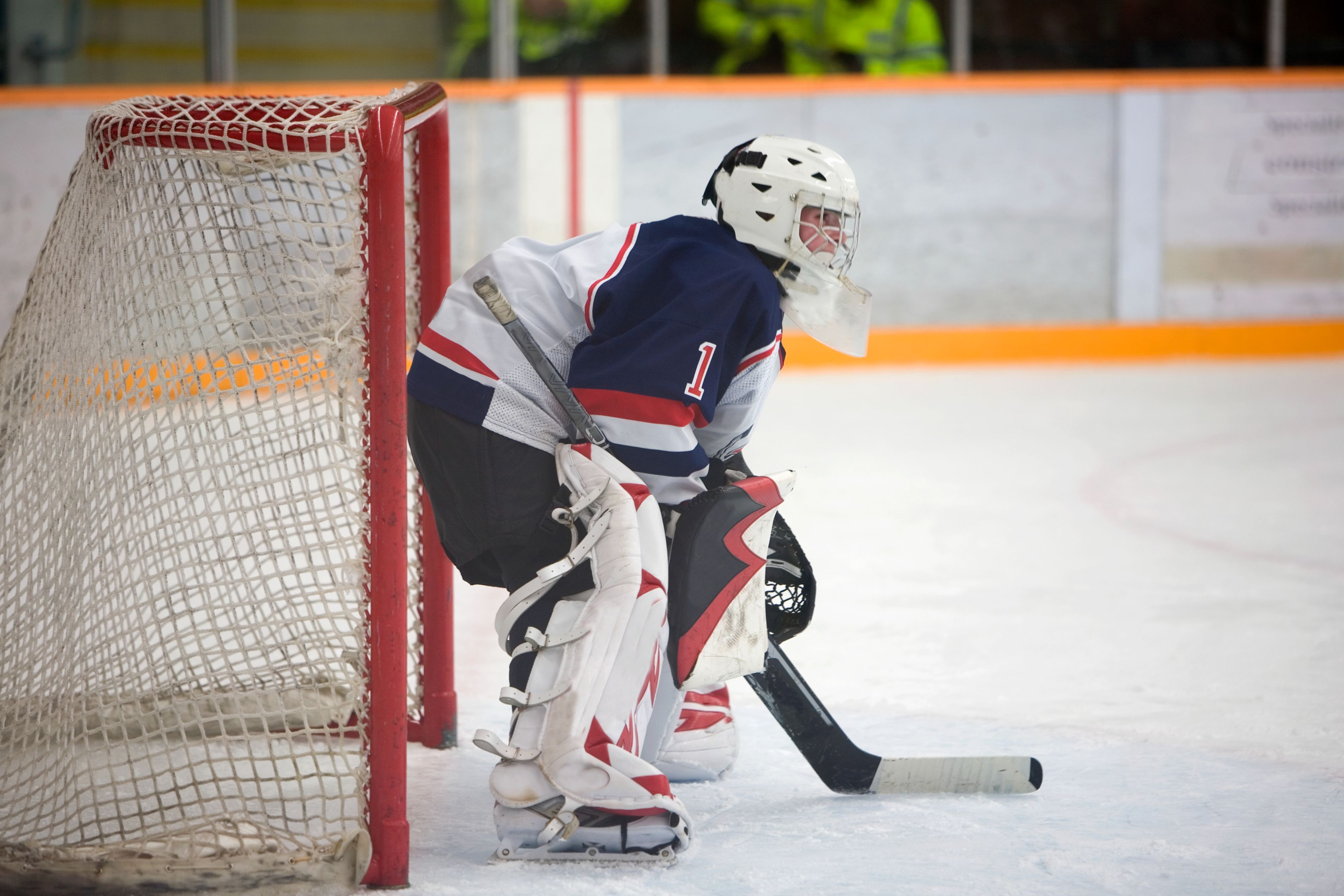 Hockey puck and stick on ice rink.