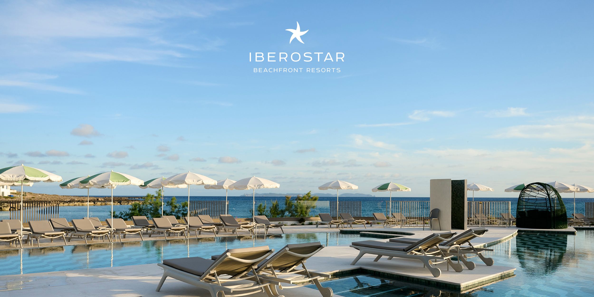 Infinity-style pool deck with loungers overlooking the sea