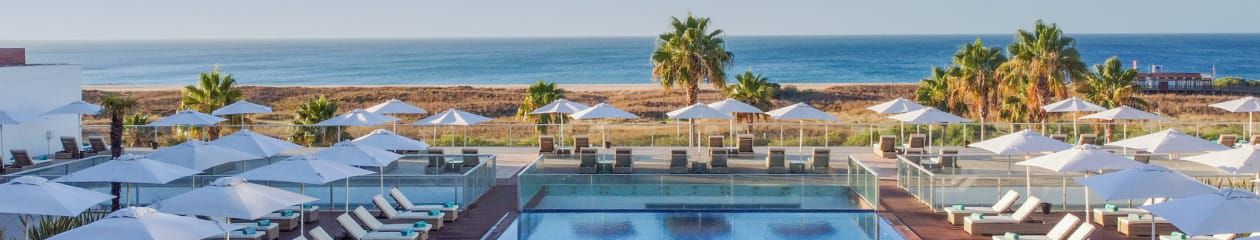 Straight on beach view of pool and cabanas