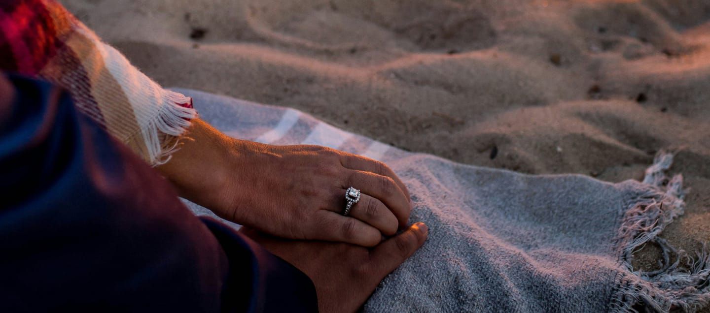 two hands on a beach blanket