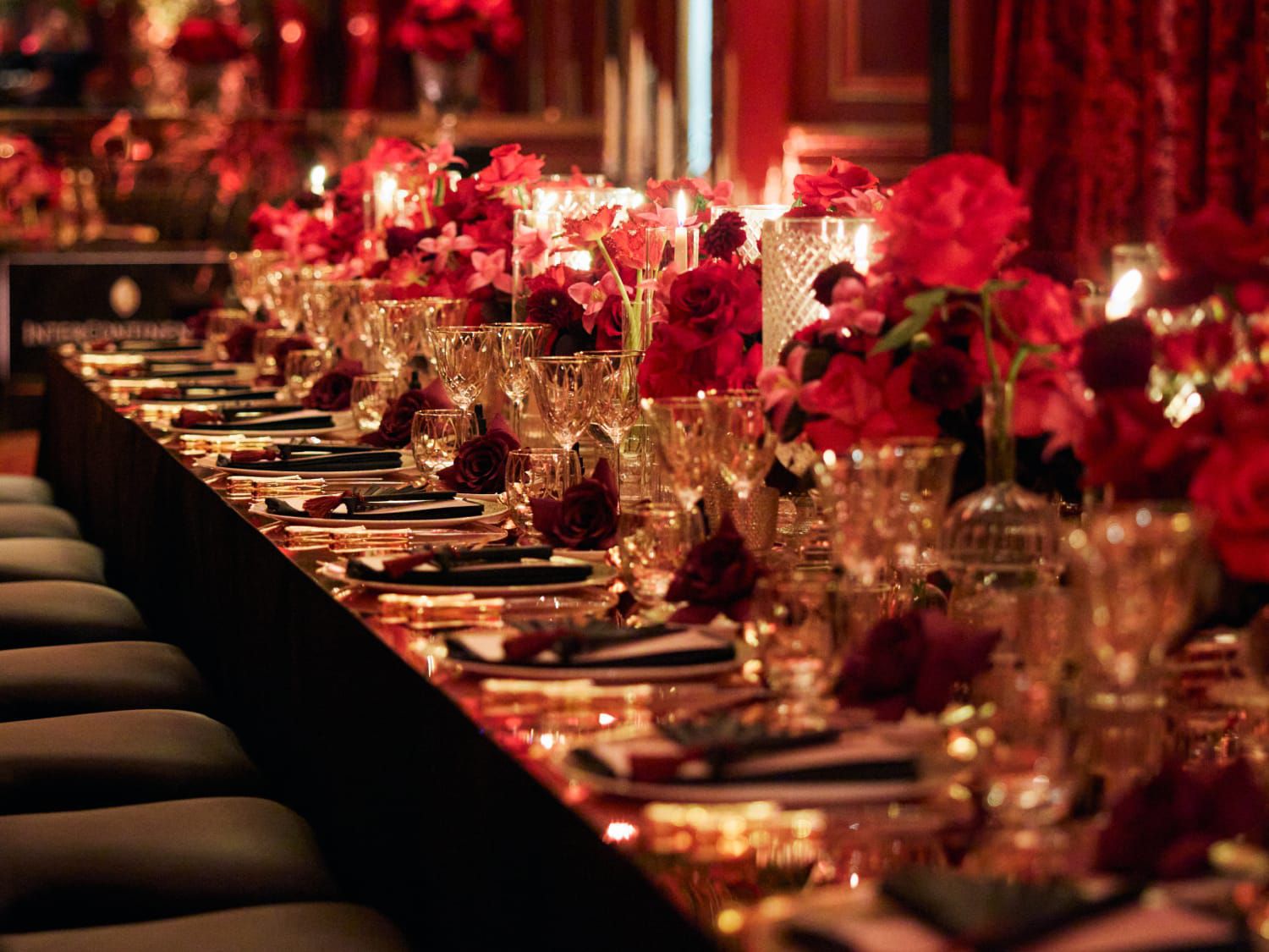 long table with glamorous formal table setting and red flowers