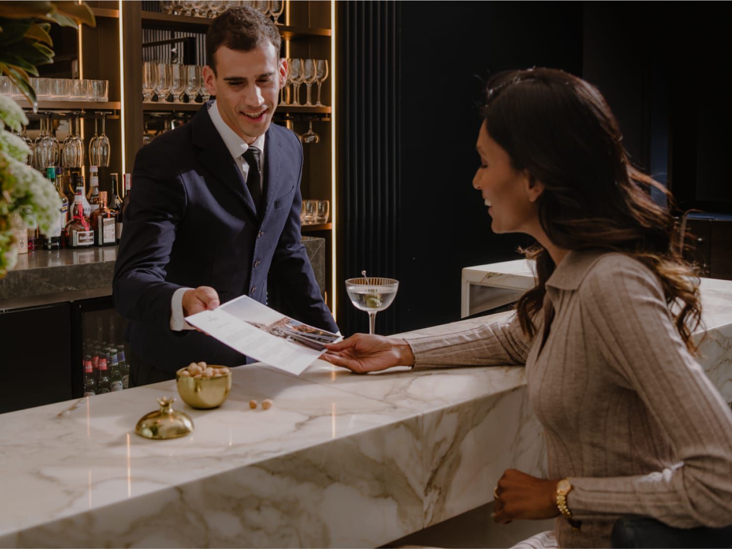 bartender handing a guest a menu