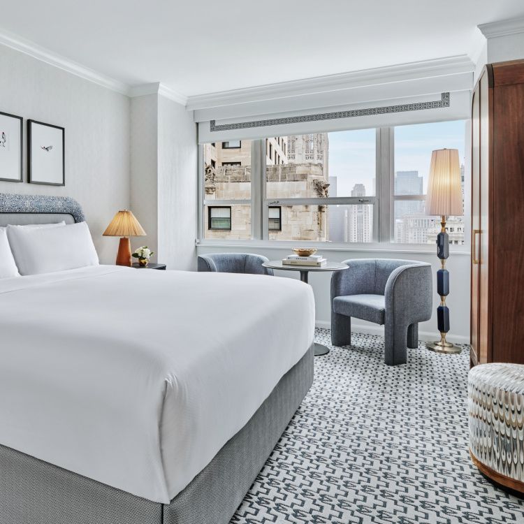 guestroom with crisp white med and view of chicago