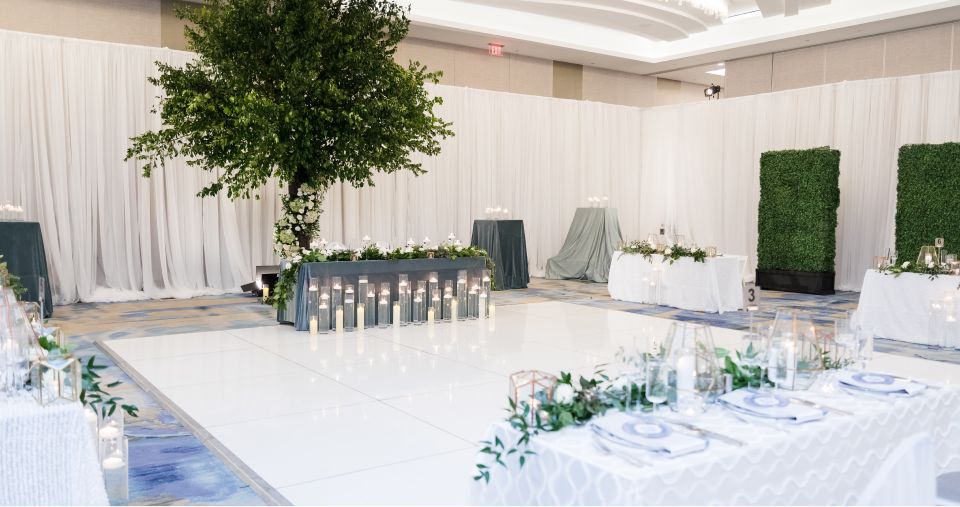 Ballroom set for a wedding with a dance floor and tables 