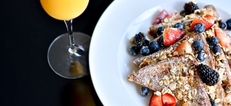 French toast topped with granola strawberries and blueberries