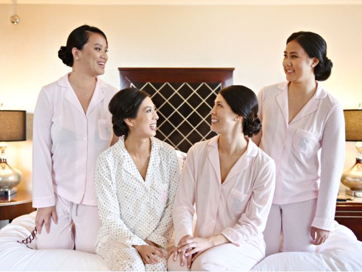 Bride and bridesmaids posing on a bed