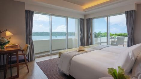 Ocean-facing twin room interior at ANA InterContinental Manza Beach Resort with bright natural light and coastal decor