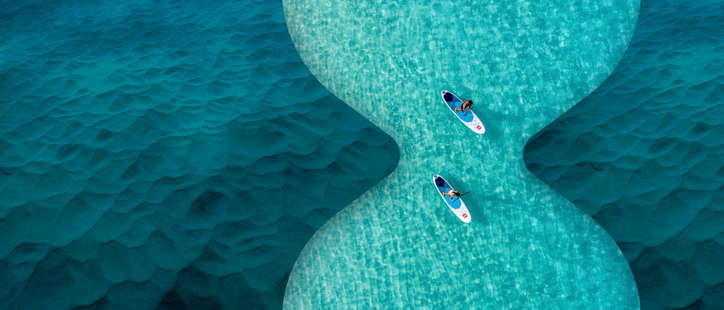Aerial view of 2 people stand up paddle boarding 