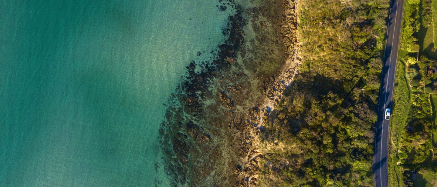 Aeiral view of car driving along a coastline