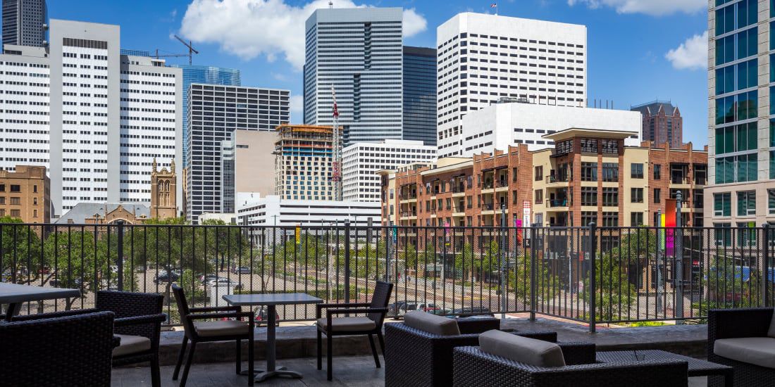 Rooftop-style terrace with tables and urban skyline