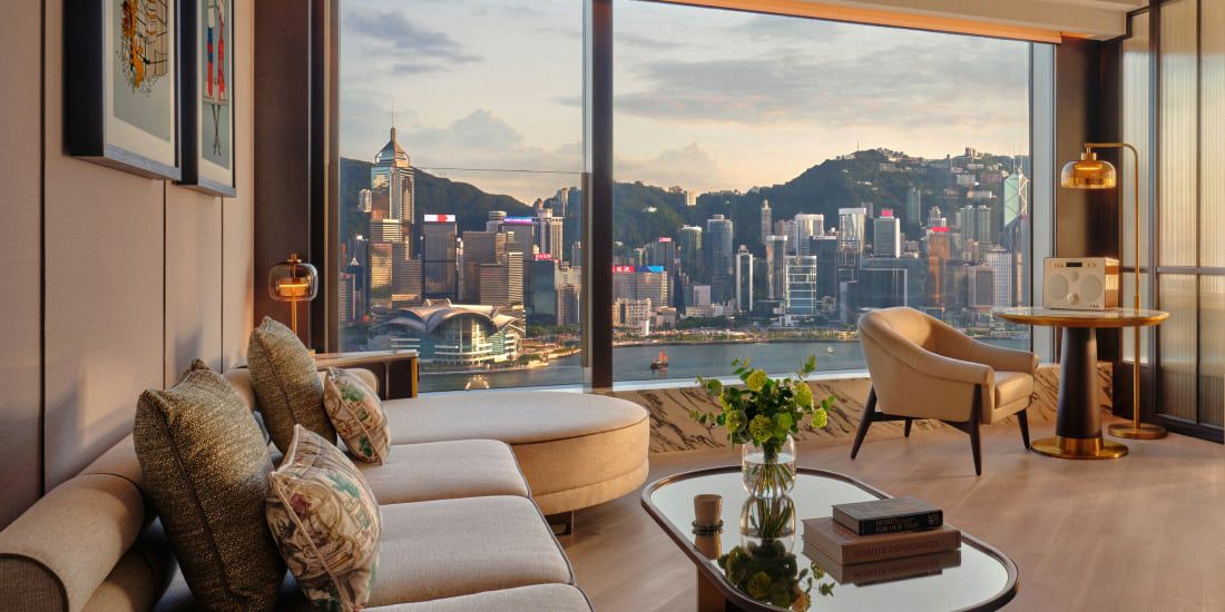 Luxury hotel suite with floor‑to‑ceiling windows and city view