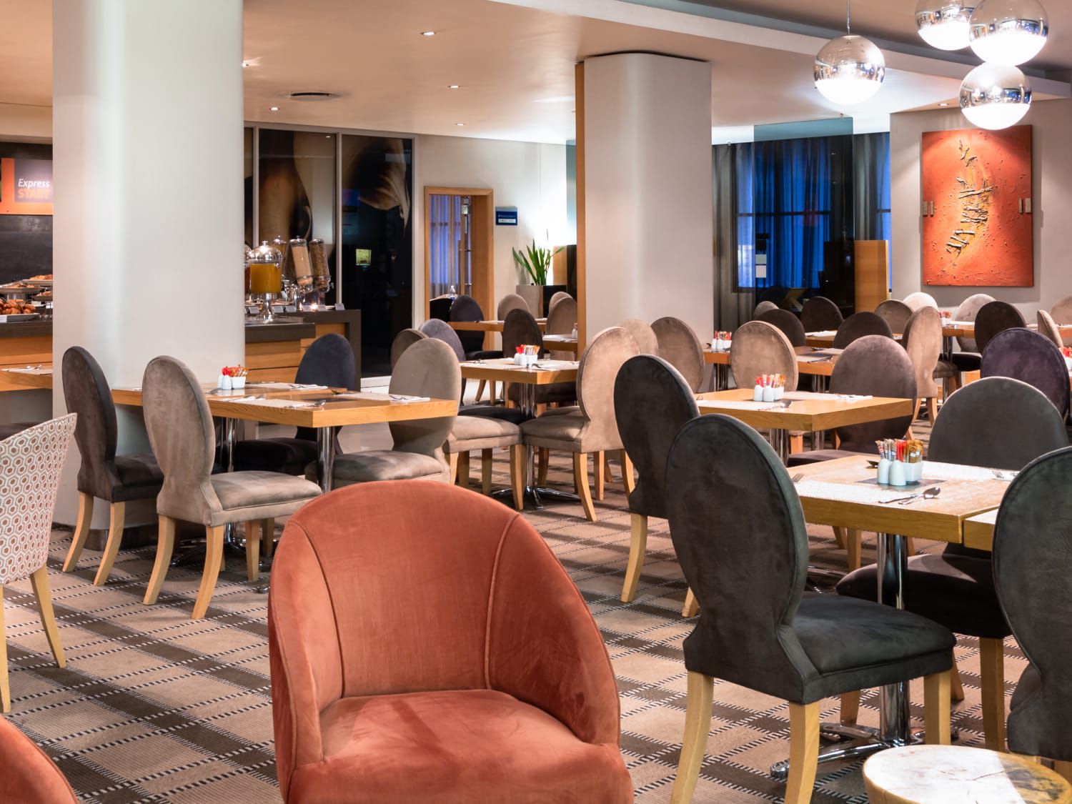 A vibrant orange and gray breakfast area at Holiday Inn Express Cape Town City Centre.