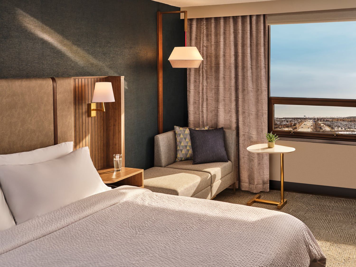 Bed with lounge area and window with city view