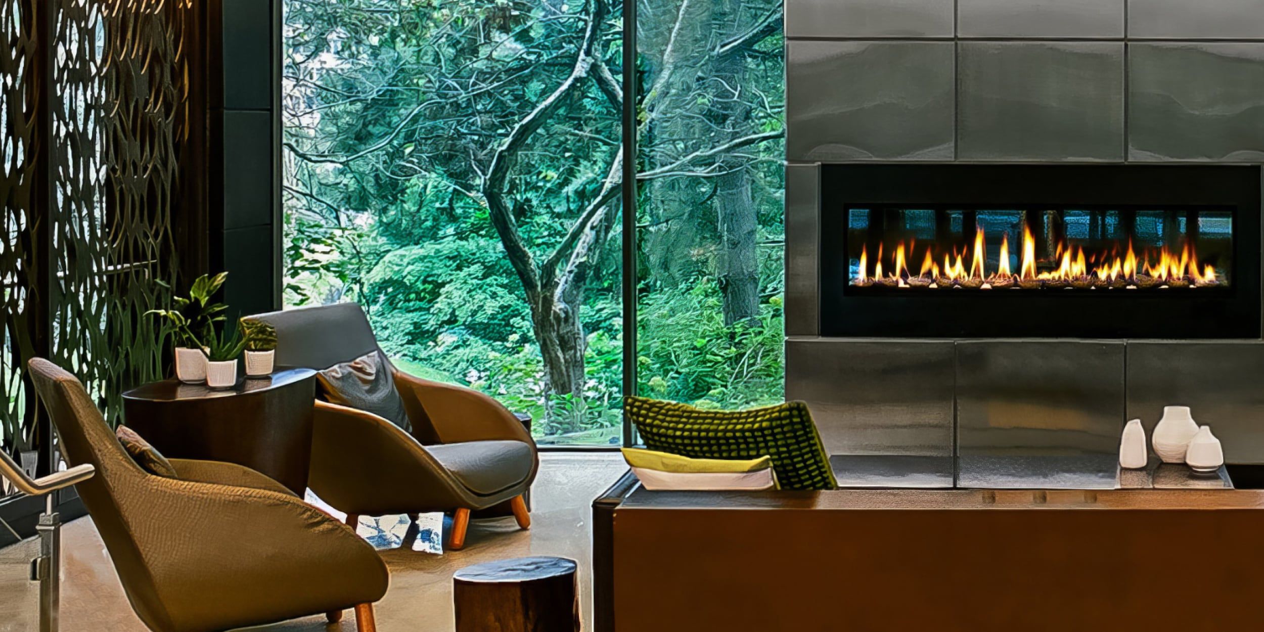 Cosy lobby lounge with fireplace and window views of lush foliage.