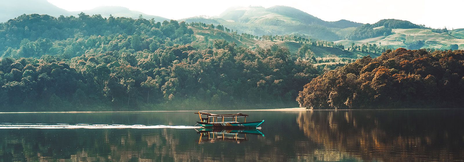 Perahu meluncur melintasi danau pada hari yang cerah 