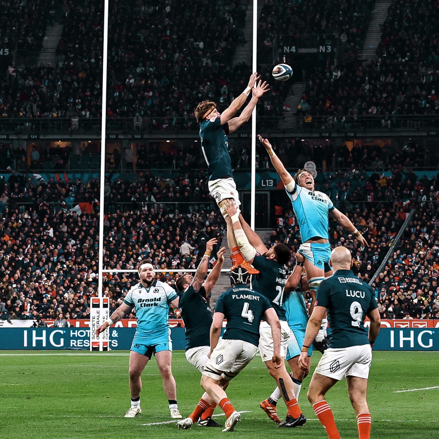 A pair of IHG Hotels & Resorts branded tennis balls and racquets laying in front of an IHG Hotels & Resorts branded garden wall